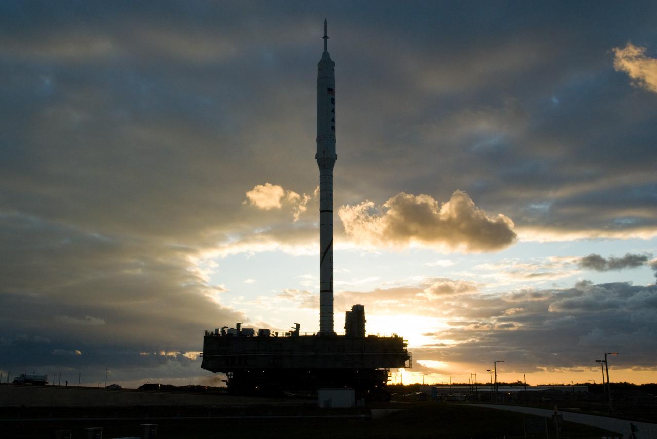 CAPE CANAVERAL, Fla. – The towering 327-foot-tall Ares I-X rocket is silhouetted again the early morning sky as it lumbers along the 4.2-mile route to Launch Pad 39B at NASA's Kennedy Space Center in Florida.    The test rocket left the Vehicle Assembly Building at 1:39 a.m. EDT on its 4.2-mile trek to the pad and was "hard down" on the pad’s pedestals at 9:17 a.m.  The transfer of the pad from the Space Shuttle Program to the Constellation Program took place May 31. Modifications made to the pad include the removal of shuttle unique subsystems, such as the orbiter access arm and a section of the gaseous oxygen vent arm, along with the installation of three 600-foot lightning towers, access platforms, environmental control systems and a vehicle stabilization system.  Part of the Constellation Program, the Ares I-X is the test vehicle for the Ares I. The Ares I-X flight test is targeted for Oct. 27. For information on the Ares I-X vehicle and flight test, visit http://www.nasa.gov/aresIX.  Photo credit: NASA/Kim Shiflett