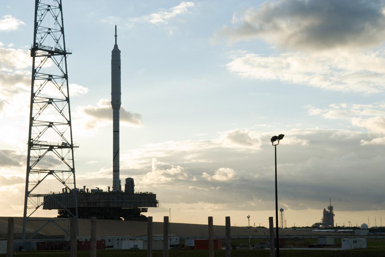 CAPE CANAVERAL, Fla. – It's a full house at NASA's Kennedy Space Center in Florida with launch vehicles on both of the center's pads.  The towering 327-foot-tall Ares I-X rocket is newly arrived on Launch Pad 39B, at left, with space shuttle Atlantis filling Launch Pad 39A in the distance.    The test rocket left the Vehicle Assembly Building at 1:39 a.m. EDT on its 4.2-mile trek to the pad and was "hard down" on the pad’s pedestals at 9:17 a.m.  The transfer of the pad from the Space Shuttle Program to the Constellation Program took place May 31. Modifications made to the pad include the removal of shuttle unique subsystems, such as the orbiter access arm and a section of the gaseous oxygen vent arm, along with the installation of three 600-foot lightning towers, access platforms, environmental control systems and a vehicle stabilization system.  Part of the Constellation Program, the Ares I-X is the test vehicle for the Ares I. The Ares I-X flight test is targeted for Oct. 27. For information on the Ares I-X vehicle and flight test, visit http://www.nasa.gov/aresIX.  Photo credit: NASA/Kim Shiflett