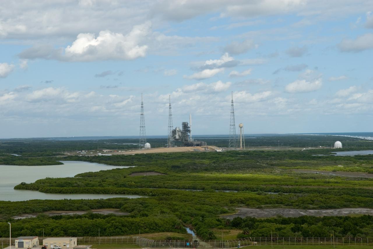 CAPE CANAVERAL, Fla. - This view from Launch Pad 39A at NASA's Kennedy Space Center in Florida shows the Ares I-X rocket on Pad 39B, ready for final processing for its upcoming flight test.  The test rocket left the Vehicle Assembly Building at 1:39 a.m. EDT on its 4.2-mile trek to the pad and was "hard down" on the pad’s pedestals at 9:17 a.m.  The transfer of the pad from the Space Shuttle Program to the Constellation Program took place May 31. Modifications made to the pad include the removal of shuttle unique subsystems, such as the orbiter access arm and a section of the gaseous oxygen vent arm, along with the installation of three 600-foot lightning towers, access platforms, environmental control systems and a vehicle stabilization system.  Part of the Constellation Program, the Ares I-X is the test vehicle for the Ares I. The Ares I-X flight test is targeted for Oct. 27. For information on the Ares I-X vehicle and flight test, visit http://www.nasa.gov/aresIX.  Photo credit: NASA/Jim Grossmann