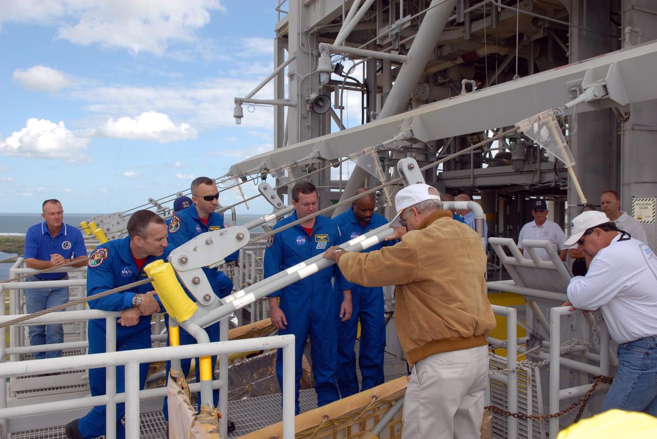 CAPE CANAVERAL, Fla. - Battalion Chief George Hoggard, back to camera, instructs members of space shuttle Atlantis' STS-129 crew on the operation of the slidewire baskets at Launch Pad 39A at NASA's Kennedy Space Center in Florida. From left are Commander Charles O. Hobaugh and Mission Specialists Randy Bresnik, Mike Foreman and Leland Melvin. The crew members of space shuttle Atlantis' STS-129 mission are at Kennedy for training related to their launch dress rehearsal, the Terminal Countdown Demonstration Test. Launch of Atlantis on its STS-129 mission to the International Space Station is targeted for Nov. 16. For information on the STS-129 mission objectives and crew, visit http://www.nasa.gov/mission_pages/shuttle/shuttlemissions/sts129/index.html. Photo credit: NASA/Jim Grossmann