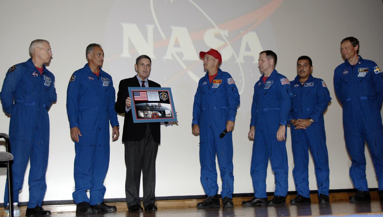 CAPE CANAVERAL, Fla. – CAPE CANAVERAL, Fla. – In the Training Auditorium at NASA's Kennedy Space Center in Florida, Center Director Bob Cabana accepts a plaque commemorating the STS-128 space shuttle mission for the STS-128 crew.  From left are Mission Specialists Patrick Forrester and John "Danny" Olivas; Cabana; Commander Rick Sturckow; Pilot Kevin Ford; and Mission Specialists Jose Hernandez and Christer Fuglesang.     More than 7 tons of supplies, science racks and equipment, as well as additional environmental hardware to sustain six crew members on the International Space Station were delivered to the International Space Station on the STS-128 mission. The equipment included a freezer to store research samples, a new sleeping compartment and the COLBERT treadmill.  The mission was the 128th in the Space Shuttle Program, the 37th flight of Discovery and the 30th station assembly flight. Launch was Aug. 28, 2009.  Photo credit: NASA/Kim Shiflett