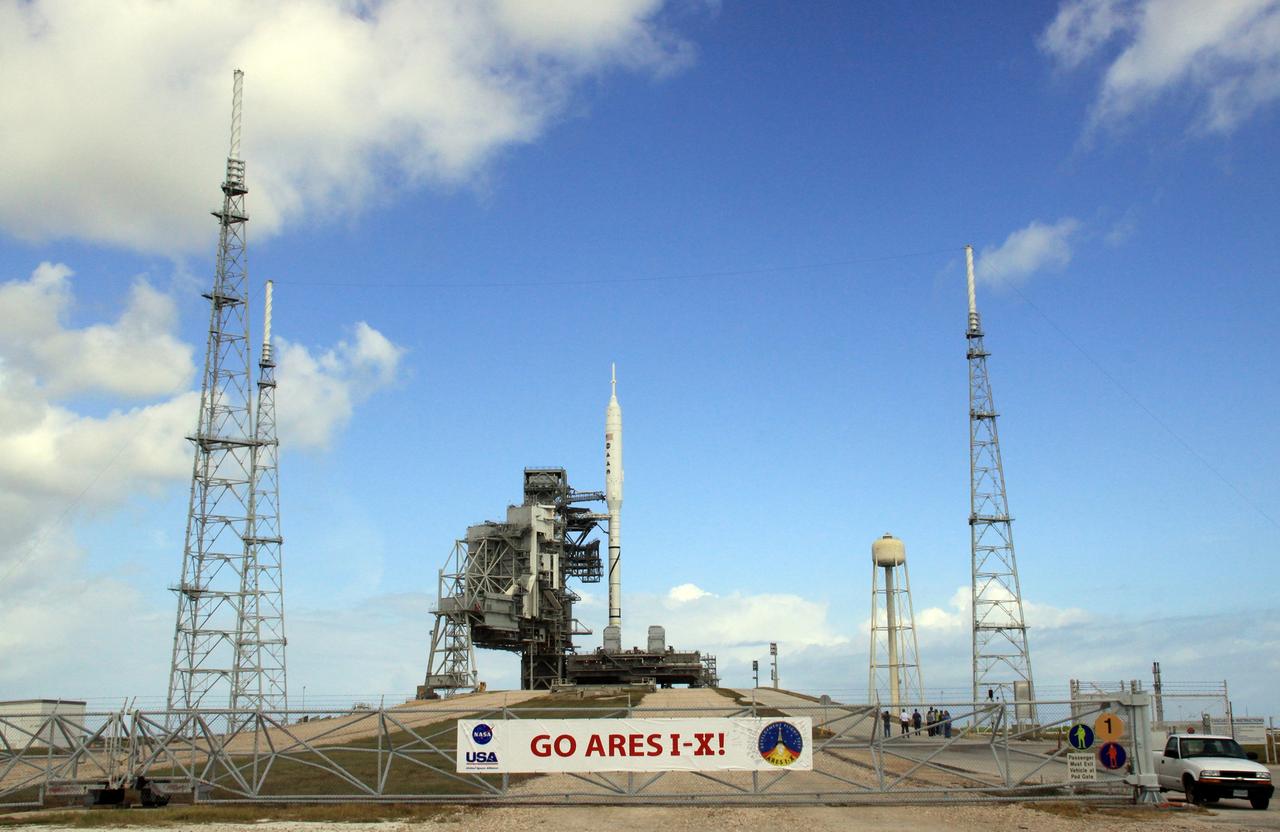 CAPE CANAVERAL, Fla. – Go Ares I-X! A banner on the perimeter fence of Launch Pad 39B at NASA's Kennedy Space Center in Florida reflects the excitement building in Kennedy's work force in anticipation of the flight test of the towering 327-foot-tall Ares I-X rocket.    This is the first time since the Apollo Program's Saturn rockets were retired that a vehicle other than the space shuttle has resided on the pad.     The transfer of the pad from the Space Shuttle Program to the Constellation Program took place May 31. Pad modifications to support the Ares I-X include the removal of shuttle unique subsystems, such as the orbiter access arm and a section of the gaseous oxygen vent arm, and the installation of three 600-foot lightning towers, access platforms, environmental control systems and a vehicle stabilization system.  Part of the Constellation Program, the Ares I-X is the test vehicle for the Ares I.  The Ares I-X flight test is set for Oct. 27.  For information on the Ares I-X vehicle and flight test, visit http://www.nasa.gov/aresIX.  Photo credit: NASA/Jack Pfaller