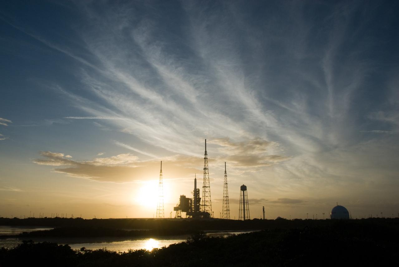 CAPE CANAVERAL, Fla. - As the sun sets behind Launch Complex 39B at NASA's Kennedy Space Center in Florida, the Ares I-X rocket awaits the approaching liftoff of its flight test.    This is the first time since the Apollo Program's Saturn rockets were retired that a vehicle other than the space shuttle has occupied the pad.   Part of the Constellation Program, the Ares I-X is the test vehicle for the Ares I.  The Ares I-X flight test is set for Oct. 27.  For information on the Ares I-X vehicle and flight test, visit http://www.nasa.gov/aresIX. Photo credit: NASA/Kim Shiflett