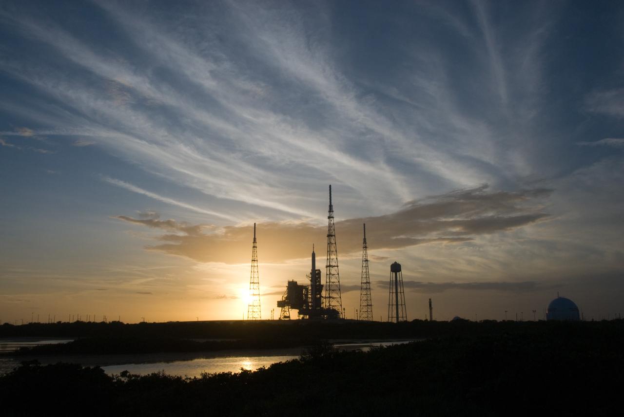 CAPE CANAVERAL, Fla. - As the sun sets behind Launch Complex 39B at NASA's Kennedy Space Center in Florida, the Ares I-X rocket awaits the approaching liftoff of its flight test.    This is the first time since the Apollo Program's Saturn rockets were retired that a vehicle other than the space shuttle has occupied the pad.   Part of the Constellation Program, the Ares I-X is the test vehicle for the Ares I.  The Ares I-X flight test is set for Oct. 27.  For information on the Ares I-X vehicle and flight test, visit http://www.nasa.gov/aresIX. Photo credit: NASA/Kim Shiflett