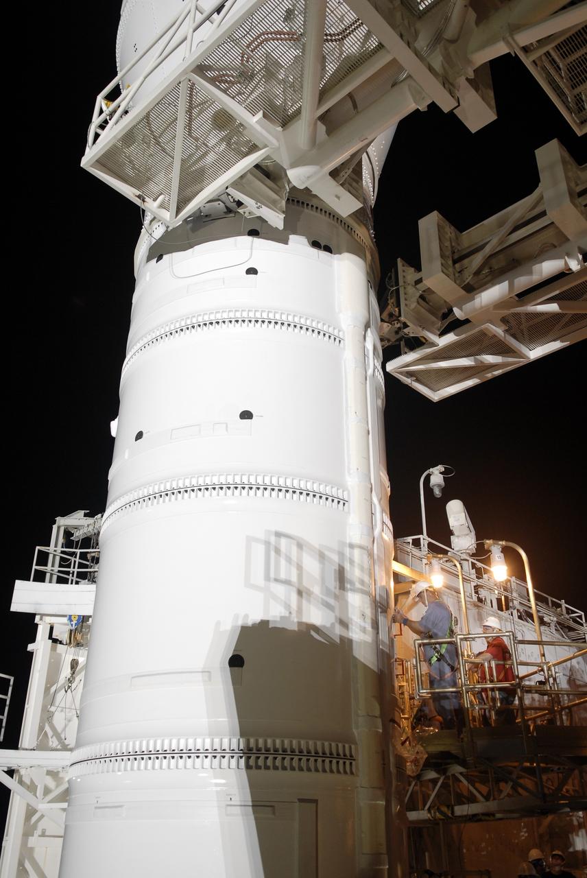 CAPE CANAVERAL, Fla. – Workers on Launch Pad 39B at NASA's Kennedy Space Center in Florida prepare the Constellation Program's 327-foot-tall Ares I-X rocket for launch. The rotating service structure and the arms of the vehicle stabilization system will be moved from around the rocket for liftoff. The transfer of the pad from the Space Shuttle Program to the Constellation Program took place May 31. Modifications made to the pad include the removal of shuttle unique subsystems, such as the orbiter access arm and a section of the gaseous oxygen vent arm, and the installation of three 600-foot lightning towers, access platforms, environmental control systems and a vehicle stabilization system. The data returned from more than 700 sensors throughout the rocket will be used to refine the design of future launch vehicles and bring NASA one step closer to reaching its exploration goals. The Ares I-X flight test is targeted for Oct. 27. For information on the Ares I-X vehicle and flight test, visit http://www.nasa.gov/aresIX. Photo credit: NASA/Kim Shiflett