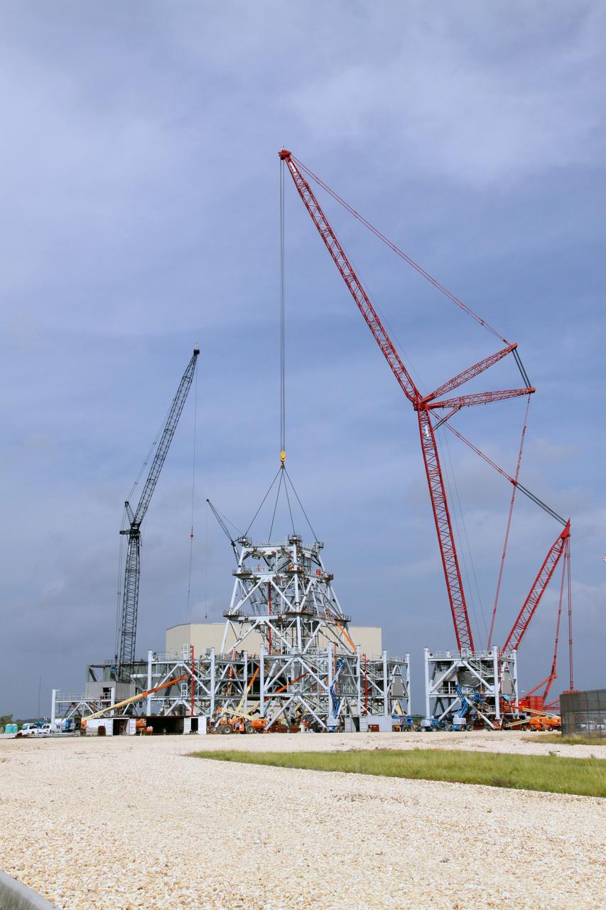 CAPE CANAVERAL, Fla. – At NASA's Kennedy Space Center in Florida, the tower on a new mobile launcher, or ML, for the Constellation Program increases in height as the third section is lowered onto the previously installed sections. Installation of the first section was on Sept. 24, and the second, on Oct. 15. The tower will have multiple platforms for personnel access and be approximately 345 feet tall. The launcher is being built at the mobile launcher park site area located north of Kennedy's Vehicle Assembly Building to support the Ares I rocket. The ML will provide a base to launch the Ares I, designed to transport the Orion crew exploration vehicle, its crew and cargo to low Earth orbit. The base is being made lighter than space shuttle mobile launcher platforms so the crawler-transporter can pick up the heavier load of the tower and taller rocket. For information on the Ares I, visit http://www.nasa.gov/ares. Photo credit: NASA/Jack Pfaller