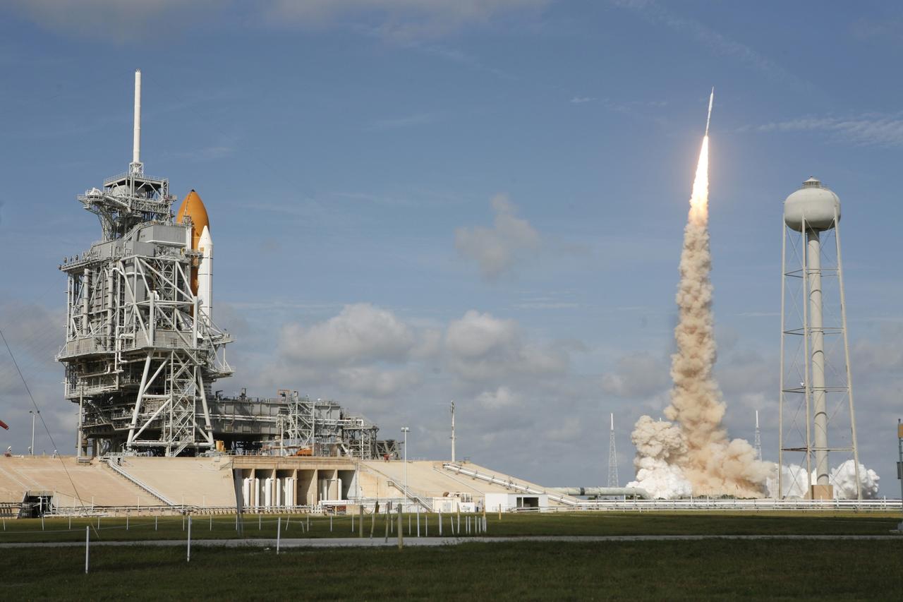 CAPE CANAVERAL, Fla. - With more than 12 times the thrust produced by a Boeing 747 jet aircraft, the Constellation Program's Ares I-X test rocket roars off Launch Pad 39B at NASA's Kennedy Space Center in Florida.  The rocket produces 2.96 million pounds of thrust at liftoff and goes supersonic in 39 seconds.  At left is space shuttle Atlantis, poised on Launch Pad 39A for liftoff, targeted for Nov. 16.    Liftoff of the 6-minute flight test was at 11:30 a.m. EDT Oct. 28. This was the first launch from Kennedy's pads of a vehicle other than the space shuttle since the Apollo Program's Saturn rockets were retired.  The parts used to make the Ares I-X booster flew on 30 different shuttle missions ranging from STS-29 in 1989 to STS-106 in 2000. The data returned from more than 700 sensors throughout the rocket will be used to refine the design of future launch vehicles and bring NASA one step closer to reaching its exploration goals.  For information on the Ares I-X vehicle and flight test, visit http://www.nasa.gov/aresIX.  Photo courtesy of Scott Andrews