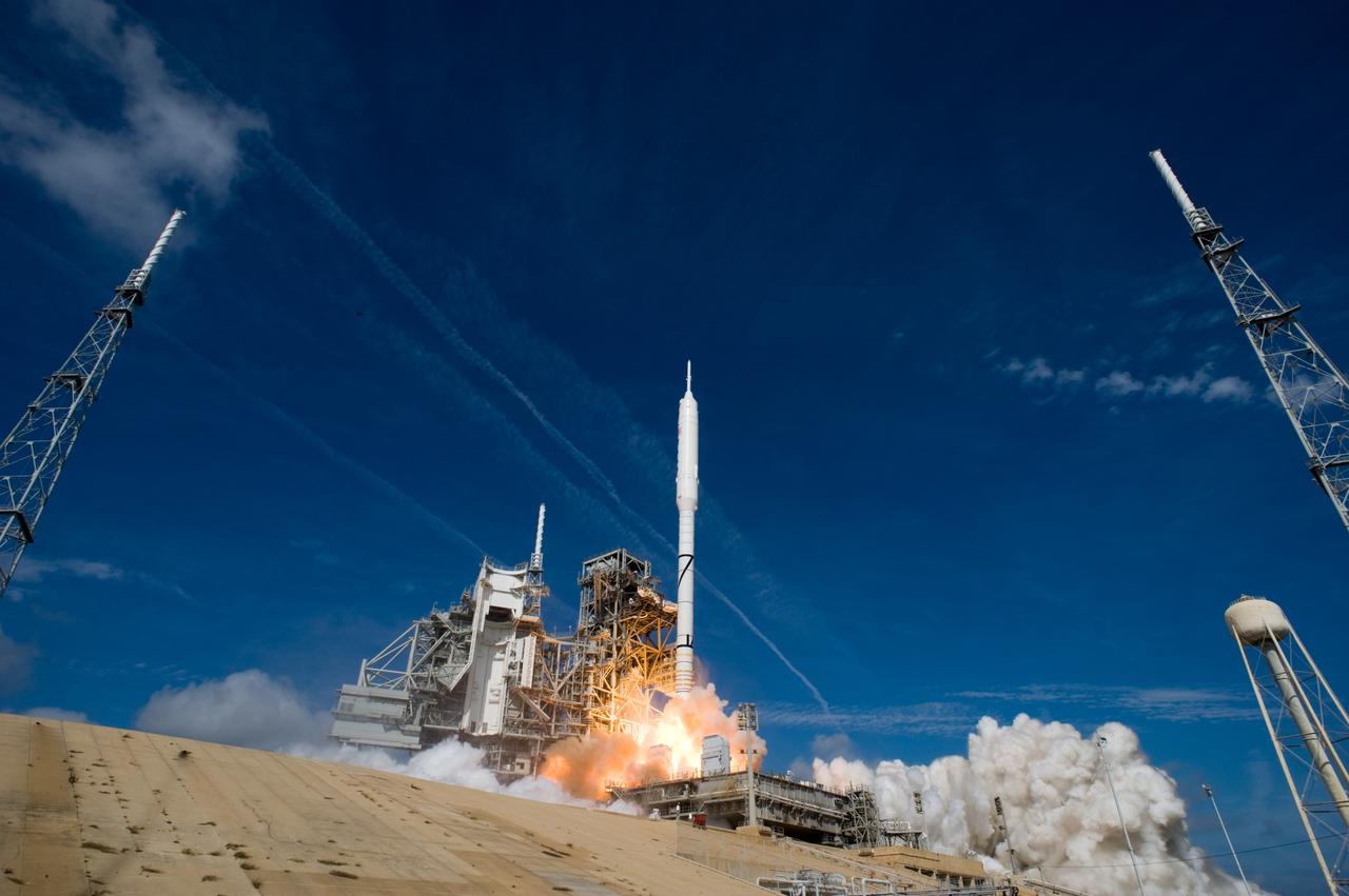 CAPE CANAVERAL, Fla. – Two of the lightning towers frame the Ares I-X test rocket as it takes off from Launch Pad 39B at NASA's Kennedy Space Center in Florida at 11:30 a.m. EDT Oct. 28. NASA’s Constellation Program's 327-foot-tall rocket produces 2.96 million pounds of thrust at liftoff and reaches a speed of 100 mph in eight seconds. This was the first launch from Kennedy's pads of a vehicle other than the space shuttle since the Apollo Program's Saturn rockets were retired. The parts used to make the Ares I-X booster flew on 30 different shuttle missions ranging from STS-29 in 1989 to STS-106 in 2000. The data returned from more than 700 sensors throughout the rocket will be used to refine the design of future launch vehicles and bring NASA one step closer to reaching its exploration goals. For information on the Ares I-X vehicle and flight test, visit http://www.nasa.gov/aresIX. Photo credit: NASA/ Sandra Joseph and Kevin O'Connell