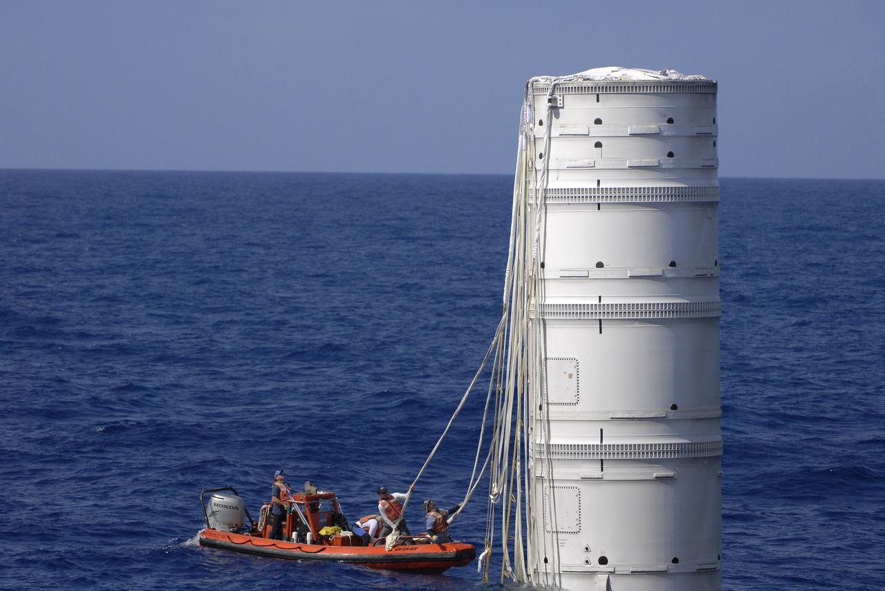 CAPE CANAVERAL, Fla. – In the Atlantic Ocean off the coast of NASA's Kennedy Space Center in Florida, United Space Alliance Recovery Operations personnel grab the parachute lines hanging from the floating Ares I-X first stage following the launch of the flight test mission.    Liftoff of the 6-minute flight test was at 11:30 a.m. EDT Oct. 28. This was the first launch from Kennedy's pads of a vehicle other than the space shuttle since the Apollo Program's Saturn rockets were retired.  The parts used to make the Ares I-X booster flew on 30 different shuttle missions ranging from STS-29 in 1989 to STS-106 in 2000. The data returned from more than 700 sensors throughout the rocket will be used to refine the design of future launch vehicles and bring NASA one step closer to reaching its exploration goals.  For information on the Ares I-X vehicle and flight test, visit http://www.nasa.gov/aresIX.  Photo credit: United Space Alliance