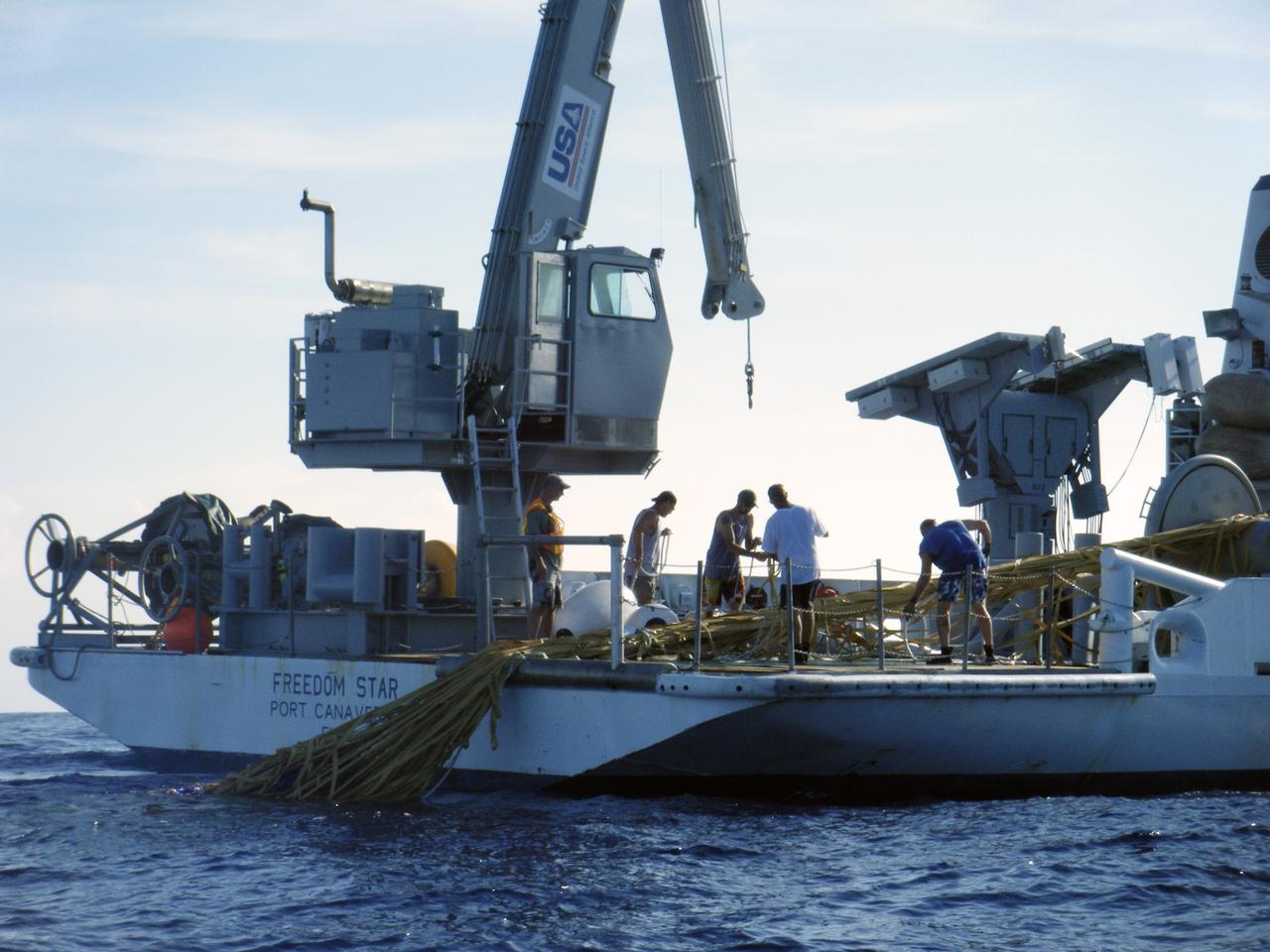 CAPE CANAVERAL, Fla. – In the Atlantic Ocean off the coast of NASA's Kennedy Space Center in Florida, United Space Alliance Recovery Operations divers and personnel aboard the solid rocket booster recovery ship Freedom Star prepare to locate, secure and tow the Ares I-X first stage back to the center following the launch of the flight test mission.    Liftoff of the 6-minute flight test was at 11:30 a.m. EDT Oct. 28. This was the first launch from Kennedy's pads of a vehicle other than the space shuttle since the Apollo Program's Saturn rockets were retired.  The parts used to make the Ares I-X booster flew on 30 different shuttle missions ranging from STS-29 in 1989 to STS-106 in 2000. The data returned from more than 700 sensors throughout the rocket will be used to refine the design of future launch vehicles and bring NASA one step closer to reaching its exploration goals.  For information on the Ares I-X vehicle and flight test, visit http://www.nasa.gov/aresIX.  Photo credit: United Space Alliance