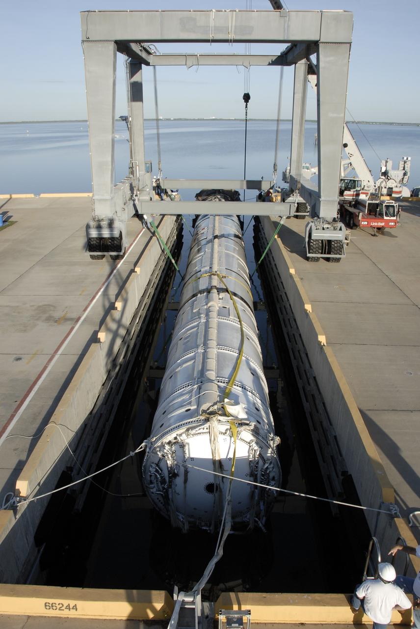 CAPE CANAVERAL, Fla. – At Hangar AF on Cape Canaveral Air Force Station in Florida, workers prepare to inspect the spent first stage of NASA's Ares I-X rocket, secured in a slip.  The booster was recovered by the solid rocket booster recovery ship Freedom Star after it splashed down in the Atlantic Ocean following its flight test.    Liftoff of the 6-minute flight test was at 11:30 a.m. EDT Oct. 28. This was the first launch from Kennedy's pads of a vehicle other than the space shuttle since the Apollo Program's Saturn rockets were retired.  The parts used to make the Ares I-X booster flew on 30 different shuttle missions ranging from STS-29 in 1989 to STS-106 in 2000. The data returned from more than 700 sensors throughout the rocket will be used to refine the design of future launch vehicles and bring NASA one step closer to reaching its exploration goals.  For information on the Ares I-X vehicle and flight test, visit http://www.nasa.gov/aresIX.  Photo credit: NASA/Kim Shiflett