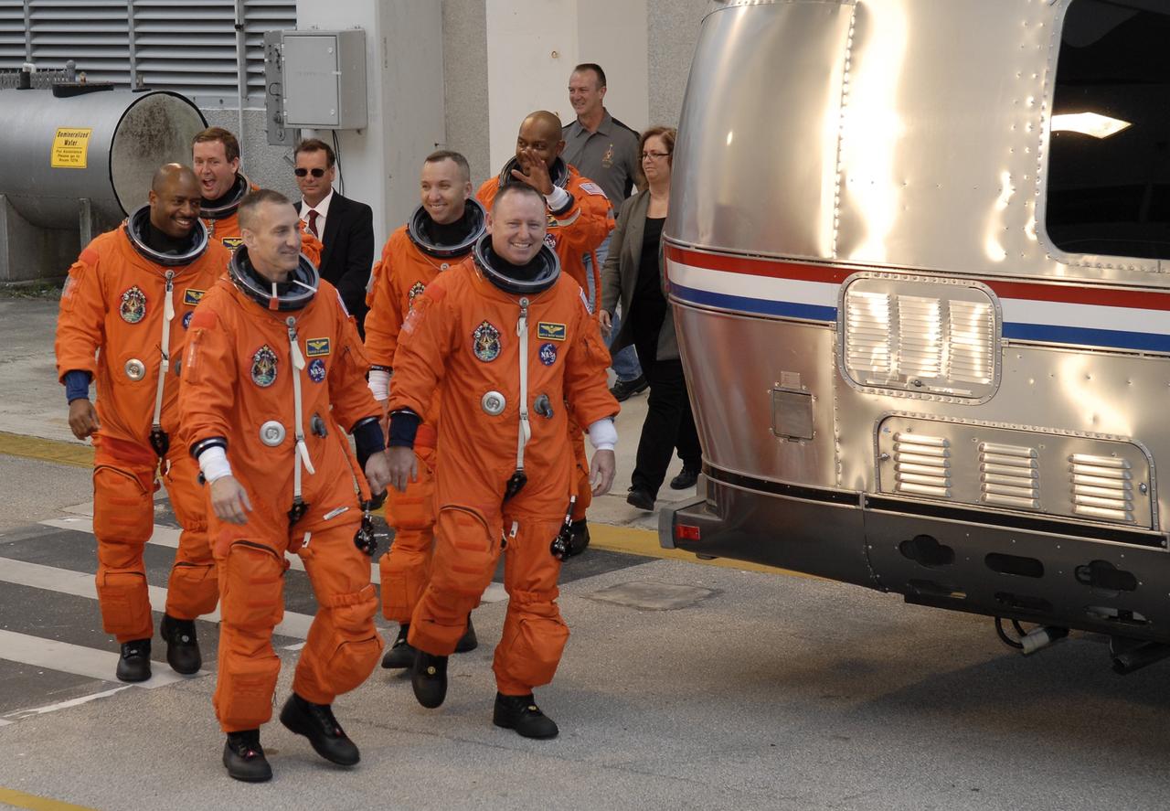 CAPE CANAVERAL, Fla. - At NASA's Kennedy Space Center in Florida, the members of the STS-129 crew exit the Operations and Checkout Building in their launch-and-entry suits to catch a ride in the Astrovan to Launch Pad 39A.  The six astronauts for space shuttle Atlantis’ STS-129 mission are participating in their launch dress rehearsal, the Terminal Countdown Demonstration Test.  From left are Mission Specialists Leland Melvin and Mike Foreman; Commander Charles O. Hobaugh; Mission Specialist Randy Bresnik; Pilot Barry E. Wilmore; and Mission Specialist Robert L. Satcher Jr.    Additional training associated with the test was done last month, but the simulated countdown was postponed because of a scheduling conflict with the launch of NASA’s Ares I-X test rocket.  Launch of Atlantis on its STS-129 mission to the International Space Station is set for Nov. 16.  On STS-129, the crew will deliver to the station two spare gyroscopes, two nitrogen tank assemblies, two pump modules, an ammonia tank assembly and a spare latching end effector for the station's robotic arm.  For information on the STS-129 crew and mission objectives, visit http://www.nasa.gov/mission_pages/shuttle/shuttlemissions/sts129/index.html. Photo credit: NASA/Kim Shiflett