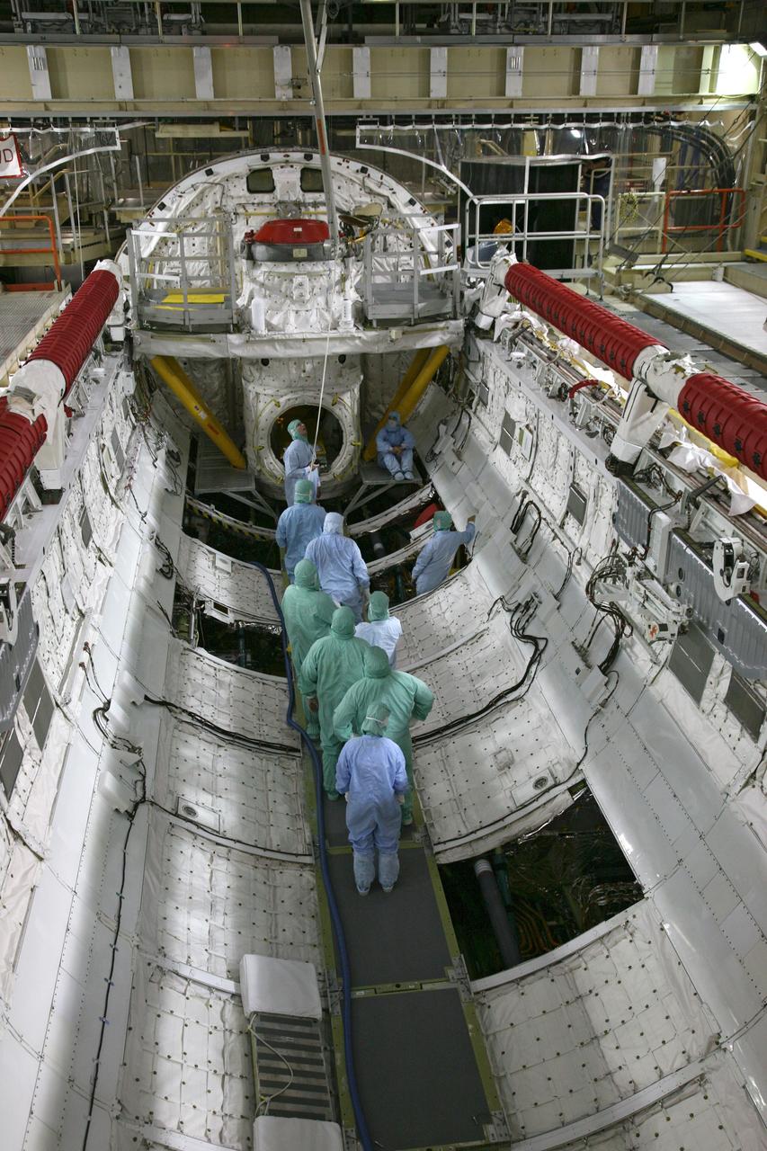 CAPE CANAVERAL, Fla. - In Orbiter Processing Facility Bay 3 at NASA's Kennedy Space Center in Florida, United Space Alliance workers lower a "fish pole" lifting fixture toward space shuttle Discovery's payload bay. The fixture will be used to remove the gaseous nitrogen pressure tank during processing for the shuttle's STS-131 mission to the International Space Station. The tanks are used for atmosphere conditioning and for moving potable water in the crew module. The seven-member STS-131 crew will deliver a Multi-Purpose Logistics Module filled with science racks to be transferred to laboratories on the station. Three spacewalks will include work to attach a spare ammonia tank assembly to the station's exterior and return a European experiment from outside the station's Columbus module. This will be the 33rd shuttle mission to the station. Launch is targeted for March 18, 2010. Photo credit: NASA/Troy Cryder