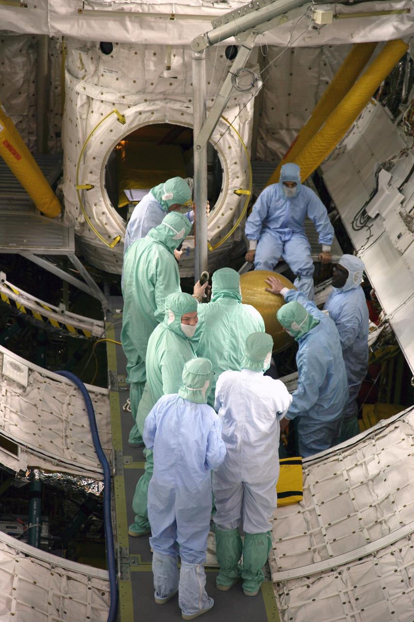 CAPE CANAVERAL, Fla. - In Orbiter Processing Facility Bay 3 at NASA's Kennedy Space Center in Florida, United Space Alliance workers attach a "fish pole" lifting fixture to the gaseous nitrogen tank in space shuttle Discovery's payload bay. The tank is being removed during processing for the shuttle's STS-131 mission to the International Space Station. The tanks are used for atmosphere conditioning and for moving potable water in the crew module. The seven-member STS-131 crew will deliver a Multi-Purpose Logistics Module filled with science racks to be transferred to laboratories on the station. Three spacewalks will include work to attach a spare ammonia tank assembly to the station's exterior and return a European experiment from outside the station's Columbus module. This will be the 33rd shuttle mission to the station. Launch is targeted for March 18, 2010. Photo credit: NASA/Troy Cryder