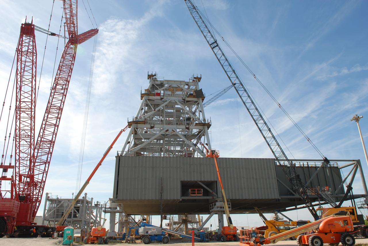 CAPE CANAVERAL, Fla. – At NASA's Kennedy Space Center in Florida, construction of the tower on a new mobile launcher, or ML, for the Constellation Program progresses. The ML's tower will have multiple platforms for personnel access and be approximately 345 feet tall. The launcher is being built at the mobile launcher park site area located north of Kennedy's Vehicle Assembly Building to support the Ares I rocket. The ML will provide a base to launch the Ares I, designed to transport the Orion crew exploration vehicle, its crew and cargo to low Earth orbit. The base is being made lighter than space shuttle mobile launcher platforms so the crawler-transporter can pick up the heavier load of the tower and taller rocket. For information on the Ares I, visit http://www.nasa.gov/ares. Photo credit: NASA/Jim Grossmann