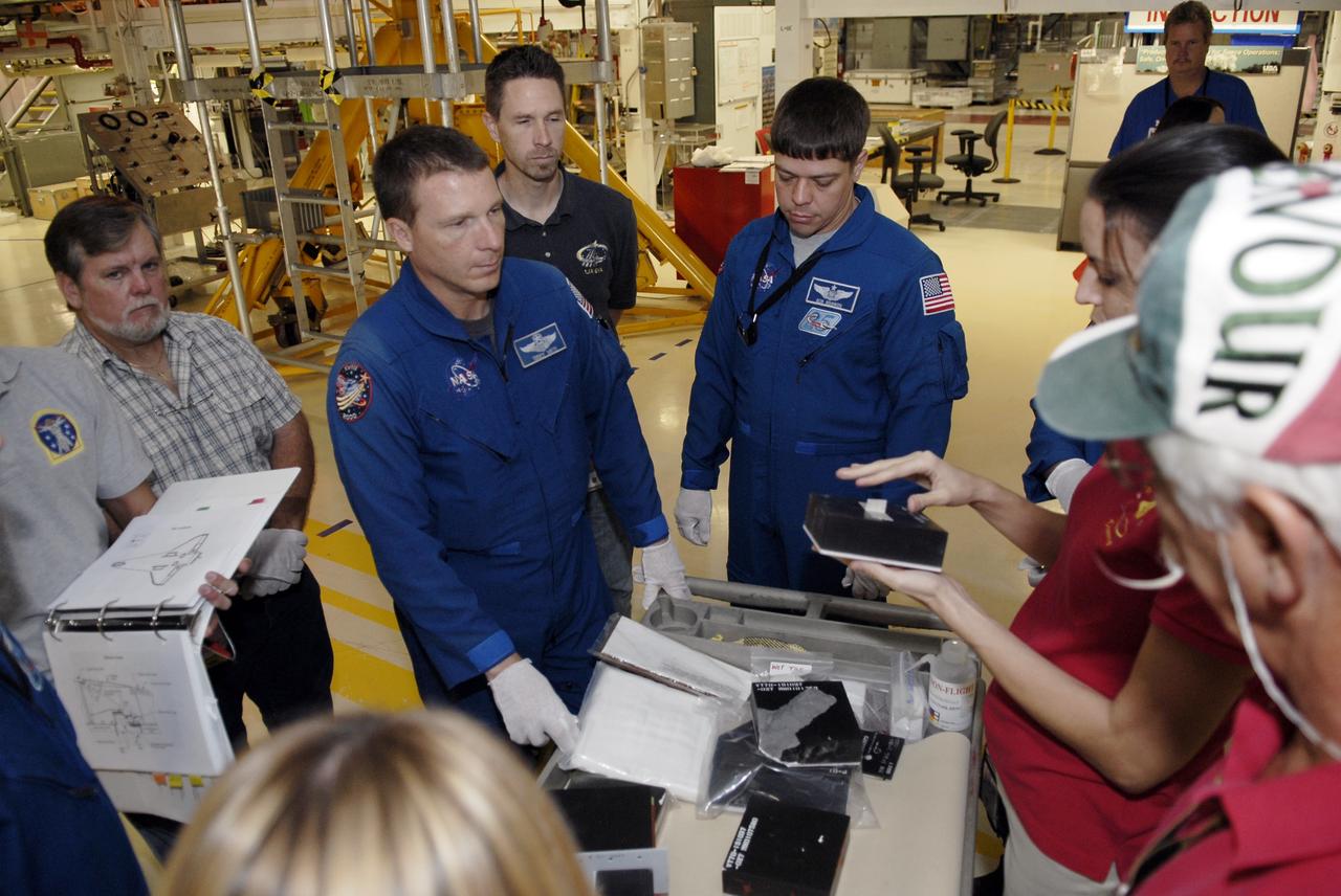 CAPE CANAVERAL, Fla. – In Orbiter Processing Facility-3 at NASA's Kennedy Space Center in Florida, STS-130 Pilot Terry Virts Jr., left, and Mission Specialist Robert Behnken receive a briefing on space shuttle Endeavour's thermal protection system.    The crew is at Kennedy for a crew equipment interface test, or CEIT, which provides hands-on training and observation of shuttle and flight hardware.  The STS-130 flight will carry the Tranquility pressurized module with a built-in cupola to the International Space Station aboard Endeavour.  Launch is targeted for Feb. 4, 2010. Photo credit: NASA/Kim Shiflett