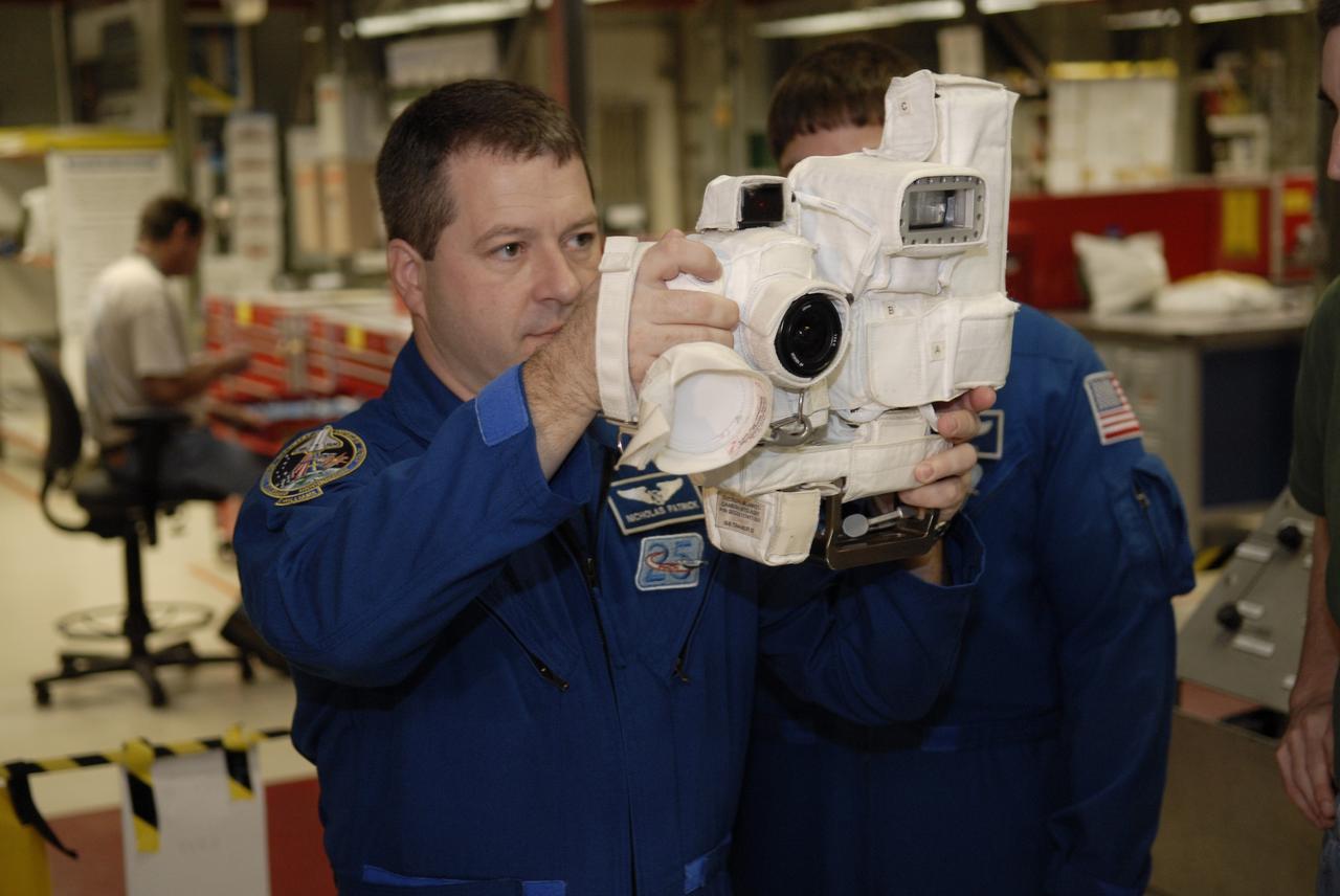 CAPE CANAVERAL, Fla. – In Orbiter Processing Facility-3 at NASA's Kennedy Space Center in Florida, STS-130 Mission Specialist Nicolas Patrick takes an opportunity to operate a camera that will fly on space shuttle Endeavour.    The crew is at Kennedy for a crew equipment interface test, or CEIT, which provides hands-on training and observation of shuttle and flight hardware.  The STS-130 flight will carry the Tranquility pressurized module with a built-in cupola to the International Space Station aboard Endeavour.  Launch is targeted for Feb. 4, 2010. Photo credit: NASA/Kim Shiflett