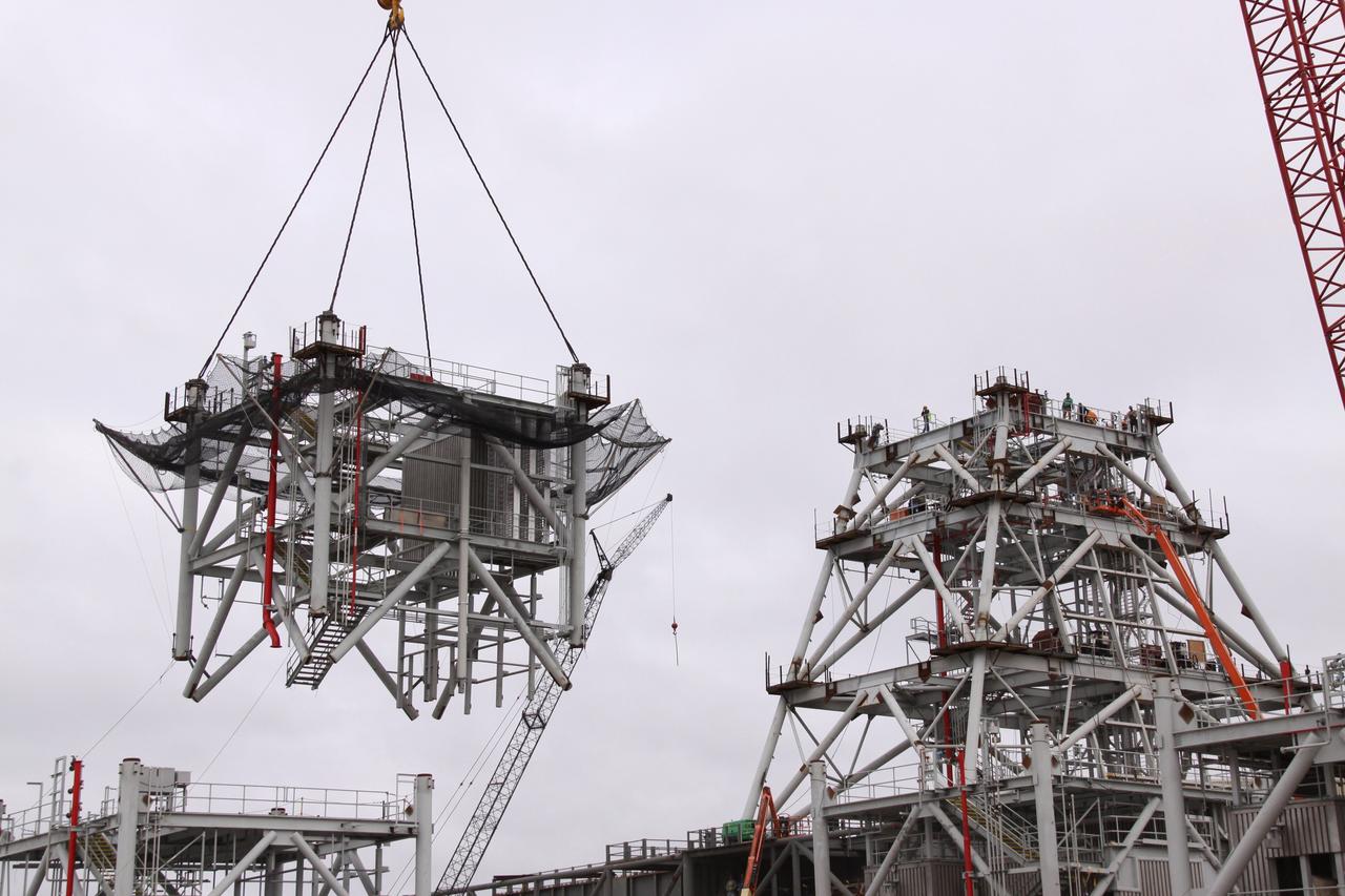 CAPE CANAVERAL, Fla. – At NASA's Kennedy Space Center in Florida, the fourth section of tower is lifted toward three sections already secured to a new mobile launcher, or ML, being constructed to support the Constellation Program. The tower will be approximately 345 feet tall when completed and have multiple platforms for personnel access. The ML is being built at the mobile launcher park site area north of Kennedy's Vehicle Assembly Building. The launcher will provide a base to launch the Ares I, designed to transport the Orion crew exploration vehicle, its crew and cargo to low Earth orbit. The base is being made lighter than space shuttle mobile launcher platforms so the crawler-transporter can pick up the heavier load of the tower and taller rocket. For information on the Ares I, visit http://www.nasa.gov/ares. Photo credit: NASA/Jack Pfaller