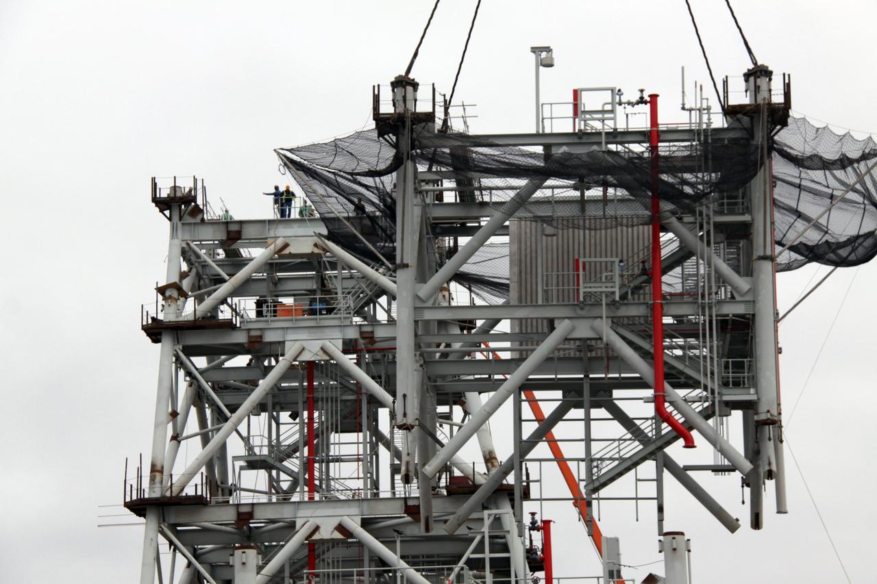 CAPE CANAVERAL, Fla. – At NASA's Kennedy Space Center in Florida, workers await the delivery of the fourth tower section atop the tower on a new mobile launcher, or ML, being constructed to support the Constellation Program. The tower will be approximately 345 feet tall when completed and have multiple platforms for personnel access. The ML is being built at the mobile launcher park site area north of Kennedy's Vehicle Assembly Building. The launcher will provide a base to launch the Ares I, designed to transport the Orion crew exploration vehicle, its crew and cargo to low Earth orbit. The base is being made lighter than space shuttle mobile launcher platforms so the crawler-transporter can pick up the heavier load of the tower and taller rocket. For information on the Ares I, visit http://www.nasa.gov/ares. Photo credit: NASA/Jack Pfaller