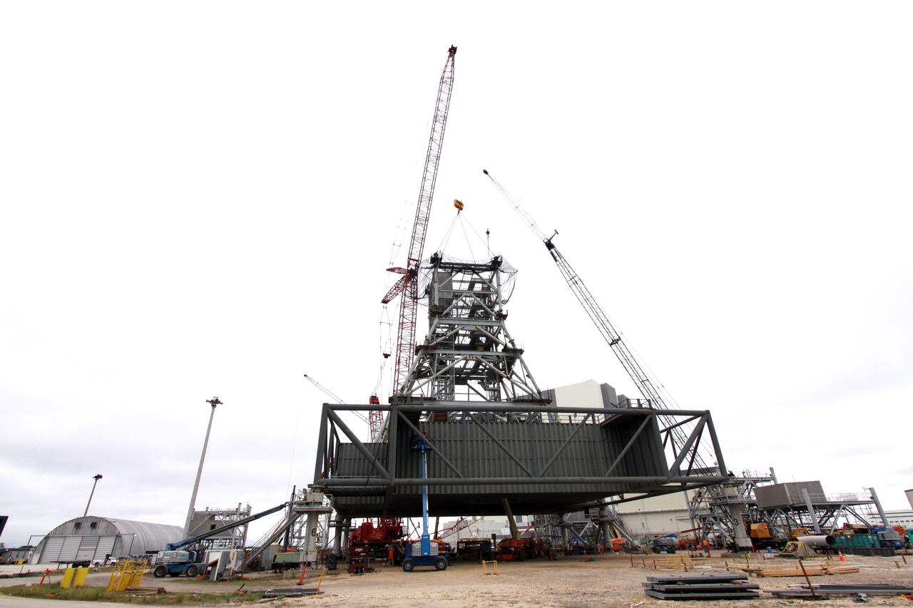 CAPE CANAVERAL, Fla. – At NASA's Kennedy Space Center in Florida, the tower on a new mobile launcher, or ML, for the Constellation Program grows as the fourth section is lowered into position. The tower will be approximately 345 feet tall when completed and have multiple platforms for personnel access. The ML is being built at the mobile launcher park site area north of Kennedy's Vehicle Assembly Building. The launcher will provide a base to launch the Ares I, designed to transport the Orion crew exploration vehicle, its crew and cargo to low Earth orbit. The base is being made lighter than space shuttle mobile launcher platforms so the crawler-transporter can pick up the heavier load of the tower and taller rocket. For information on the Ares I, visit http://www.nasa.gov/ares. Photo credit: NASA/Jack Pfaller
