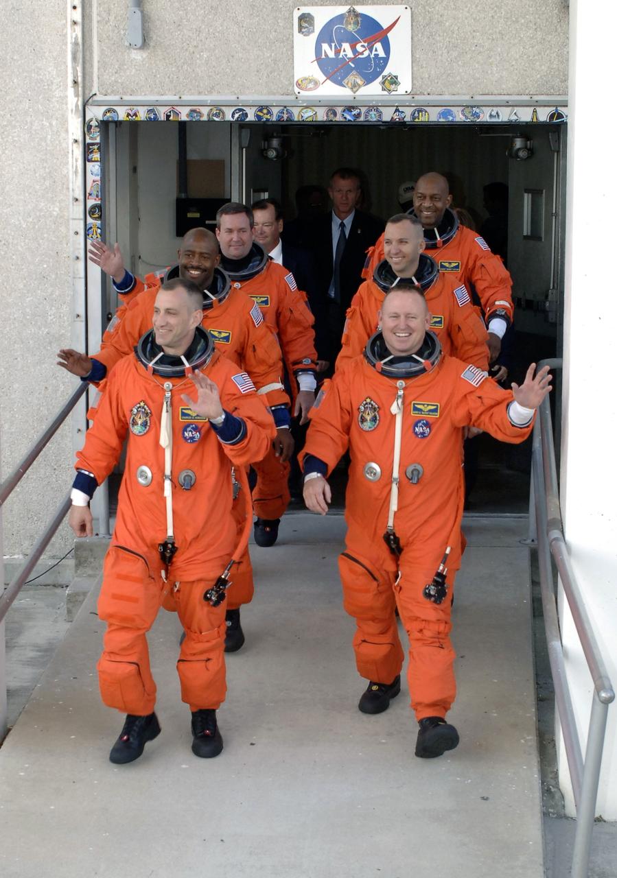 CAPE CANAVERAL, Fla. - At NASA's Kennedy Space Center in Florida, the astronauts on the STS-129 crew, dressed in their orange launch-and-entry suits, wave to spectators as they walk out of the Operations and Checkout Building for the 15-minute ride in the Astrovan to Launch Pad 39A.  In the left column, from the front, are Commander Charles O. Hobaugh and Mission Specialists Leland Melvin and Mike Foreman.  In the right column, from the front, are Pilot Barry E. Wilmore and Mission Specialists Randy Bresnik and Robert L. Satcher Jr.    Liftoff is set for 2:28 p.m. EST Nov. 16.  On STS-129, the crew will deliver two Express Logistics Carriers to the International Space Station, the largest of the shuttle's cargo carriers, containing 15 spare pieces of equipment including two gyroscopes, two nitrogen tank assemblies, two pump modules, an ammonia tank assembly and a spare latching end effector for the station's robotic arm.  Atlantis will return to Earth a station crew member, Nicole Stott, who has spent more than two months aboard the orbiting laboratory.  STS-129 is slated to be the final space shuttle Expedition crew rotation flight.  For information on the STS-129 mission and crew, visit http://www.nasa.gov/mission_pages/shuttle/shuttlemissions/sts129/index.html. Photo credit: NASA/Kim Shiflett