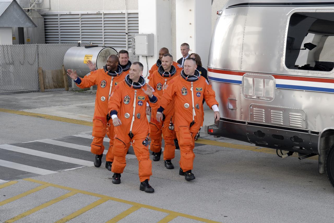 CAPE CANAVERAL, Fla. - At NASA's Kennedy Space Center in Florida, the astronauts on the STS-129 crew, dressed in their orange launch-and-entry suits, wave to spectators as they walk out of the Operations and Checkout Building for the 15-minute ride in the Astrovan to Launch Pad 39A.  From left are Mission Specialists Leland Melvin and Mike Foreman; Commander Charles O. Hobaugh; Mission Specialists Robert L. Satcher Jr. and Randy Bresnik; and Pilot Barry E. Wilmore.     Liftoff is set for 2:28 p.m. EST Nov. 16.  On STS-129, the crew will deliver two Express Logistics Carriers to the International Space Station, the largest of the shuttle's cargo carriers, containing 15 spare pieces of equipment including two gyroscopes, two nitrogen tank assemblies, two pump modules, an ammonia tank assembly and a spare latching end effector for the station's robotic arm.  Atlantis will return to Earth a station crew member, Nicole Stott, who has spent more than two months aboard the orbiting laboratory.  STS-129 is slated to be the final space shuttle Expedition crew rotation flight.  For information on the STS-129 mission and crew, visit http://www.nasa.gov/mission_pages/shuttle/shuttlemissions/sts129/index.html. Photo credit: NASA/Kim Shiflett