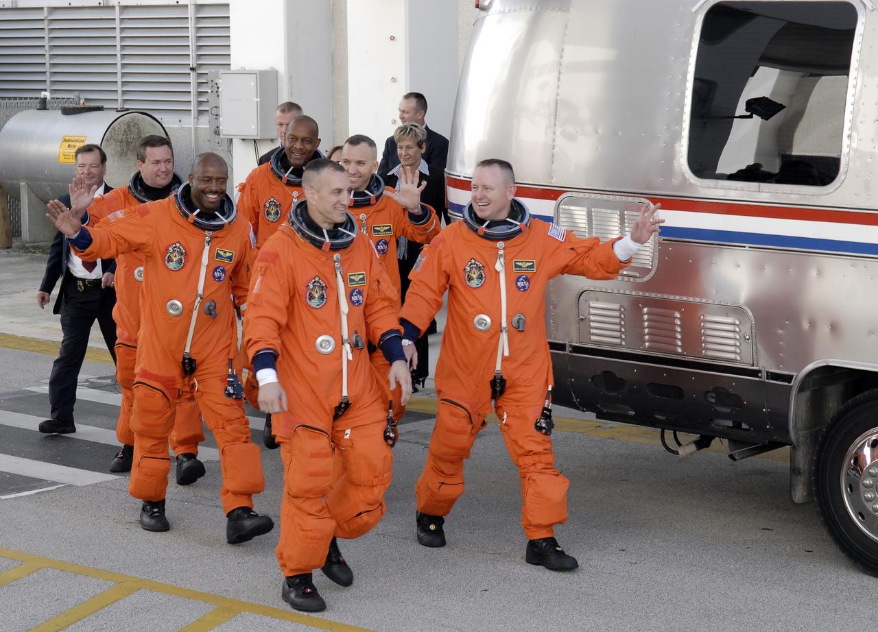 CAPE CANAVERAL, Fla. - At NASA's Kennedy Space Center in Florida, the astronauts on the STS-129 crew, dressed in their orange launch-and-entry suits, wave to spectators as they walk out of the Operations and Checkout Building for the 15-minute ride in the Astrovan to Launch Pad 39A.  From left are Mission Specialists Mike Foreman, Leland Melvin and Robert L. Satcher Jr.; Commander Charles O. Hobaugh; Mission Specialist Randy Bresnik; and Pilot Barry E. Wilmore.    Liftoff is set for 2:28 p.m. EST Nov. 16.  On STS-129, the crew will deliver two Express Logistics Carriers to the International Space Station, the largest of the shuttle's cargo carriers, containing 15 spare pieces of equipment including two gyroscopes, two nitrogen tank assemblies, two pump modules, an ammonia tank assembly and a spare latching end effector for the station's robotic arm.  Atlantis will return to Earth a station crew member, Nicole Stott, who has spent more than two months aboard the orbiting laboratory.  STS-129 is slated to be the final space shuttle Expedition crew rotation flight.  For information on the STS-129 mission and crew, visit http://www.nasa.gov/mission_pages/shuttle/shuttlemissions/sts129/index.html. Photo credit: NASA/Kim Shiflett