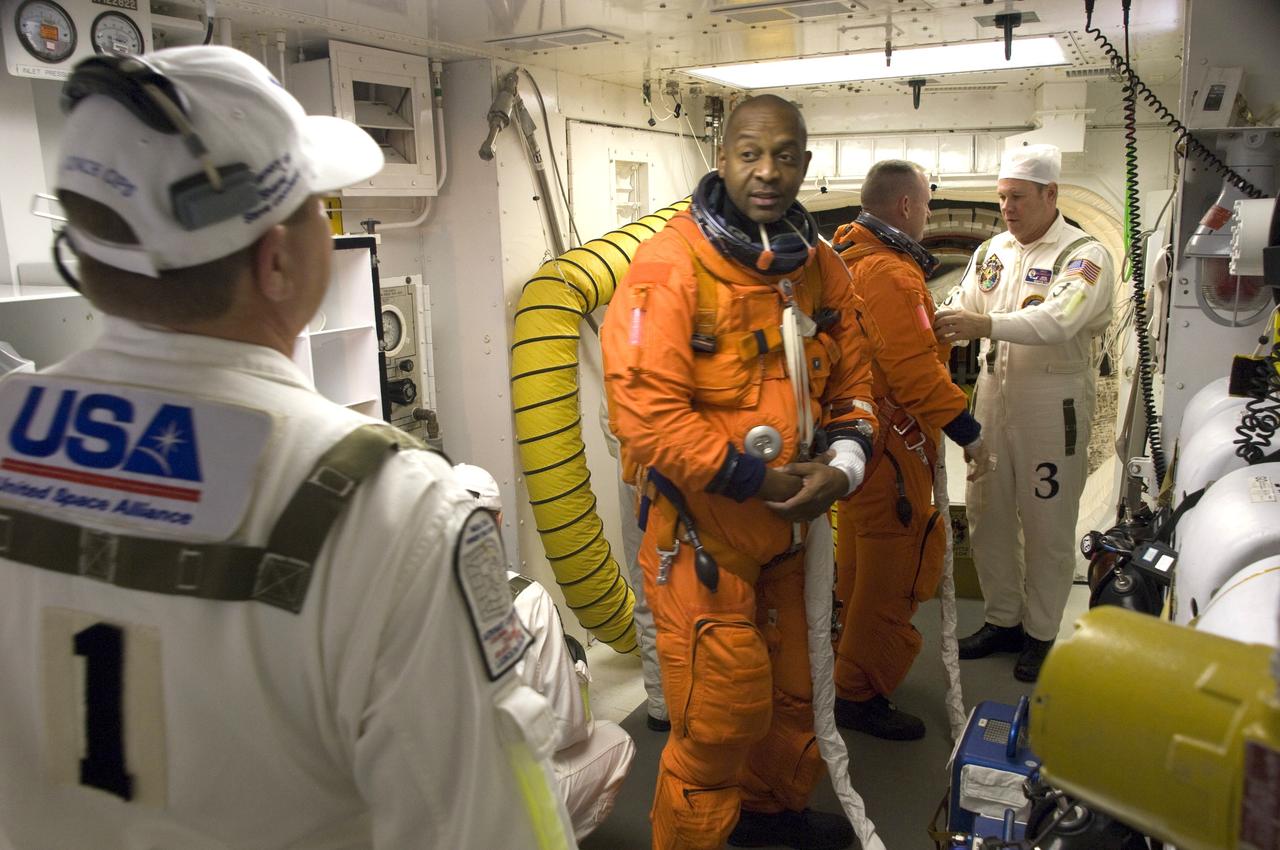 CAPE CANAVERAL, Fla. - At Launch Pad 39A at NASA's Kennedy Space Center in Florida, United Space Alliance suit technicians ensure the proper fit of the launch-and-entry suits of the STS-129 crew members. Mission Specialist Robert L. Satcher Jr. and Pilot Barry E. Wilmore, in the background, prepare to enter space shuttle Atlantis from the White Room. Liftoff is set for 2:28 p.m. EST Nov. 16. On STS-129, the crew will deliver two Express Logistics Carriers to the International Space Station, the largest of the shuttle's cargo carriers, containing 15 spare pieces of equipment including two gyroscopes, two nitrogen tank assemblies, two pump modules, an ammonia tank assembly and a spare latching end effector for the station's robotic arm. Atlantis will return to Earth a station crew member, Nicole Stott, who has spent more than two months aboard the orbiting laboratory. STS-129 is slated to be the final space shuttle Expedition crew rotation flight. For information on the STS-129 mission and crew, visit http://www.nasa.gov/mission_pages/shuttle/shuttlemissions/sts129/index.html. Photo credit: NASA/Sandra Joseph and Kevin O'Connell