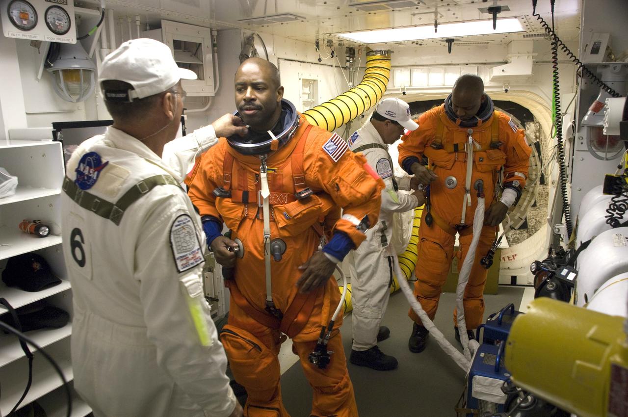 CAPE CANAVERAL, Fla. - At Launch Pad 39A at NASA's Kennedy Space Center in Florida, United Space Alliance suit technicians ensure the proper fit of the launch-and-entry suits of the STS-129 crew members. Mission Specialists Leland Melvin and Robert L. Satcher Jr., at right, prepare to enter space shuttle Atlantis from the White Room. Liftoff is set for 2:28 p.m. EST Nov. 16. On STS-129, the crew will deliver two Express Logistics Carriers to the International Space Station, the largest of the shuttle's cargo carriers, containing 15 spare pieces of equipment including two gyroscopes, two nitrogen tank assemblies, two pump modules, an ammonia tank assembly and a spare latching end effector for the station's robotic arm. Atlantis will return to Earth a station crew member, Nicole Stott, who has spent more than two months aboard the orbiting laboratory. STS-129 is slated to be the final space shuttle Expedition crew rotation flight. For information on the STS-129 mission and crew, visit http://www.nasa.gov/mission_pages/shuttle/shuttlemissions/sts129/index.html. Photo credit: NASA/Sandra Joseph and Kevin O'Connell