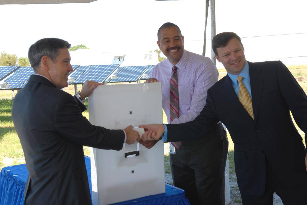 CAPE CANAVERAL, Fla. – A ceremonial "flipping of the switch" officially begins operation of NASA's first large-scale solar power generation facility at NASA's Kennedy Space Center in Florida. Flipping the four-foot-tall light switch in unison are, from left, Bob Cabana, Kennedy center director; Roderick Roche, senior manager, Project Management Office of North America, SunPower Corporation; and Eric Silagy, Florida Power & Light Company vice president and chief development officer. Representatives from NASA, Florida Power & Light Company, or FPL, and SunPower Corporation formally commissioned the one-megawatt facility and announced plans to pursue a new research, development and demonstration project at Kennedy to advance America's use of renewable energy. The facility is the first element of a major renewable energy project currently under construction at Kennedy. The completed system features a fixed-tilt, ground-mounted solar power system designed and built by SunPower, along with SunPower solar panels. A 10-megawatt solar farm, which SunPower is building on nearby Kennedy property, will supply power to FPL's customers when it is completed in April 2010. Photo credit: NASA/Jim Grossmann