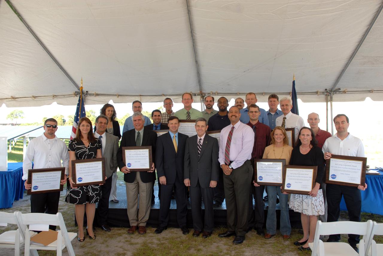 CAPE CANAVERAL, Fla. – At NASA's Kennedy Space Center in Florida, recipients of a NASA Team Award for their parts in the successful construction of NASA's first large-scale solar power generation facility pose for a group portrait. Representatives from NASA, Florida Power & Light Company, or FPL, and SunPower Corporation formally commissioned the one-megawatt facility and announced plans to pursue a new research, development and demonstration project at Kennedy to advance America's use of renewable energy. The facility is the first element of a major renewable energy project currently under construction at Kennedy. The completed system features a fixed-tilt, ground-mounted solar power system designed and built by SunPower, along with SunPower solar panels. A 10-megawatt solar farm, which SunPower is building on nearby Kennedy property, will supply power to FPL's customers when it is completed in April 2010. Photo credit: NASA/Jim Grossmann