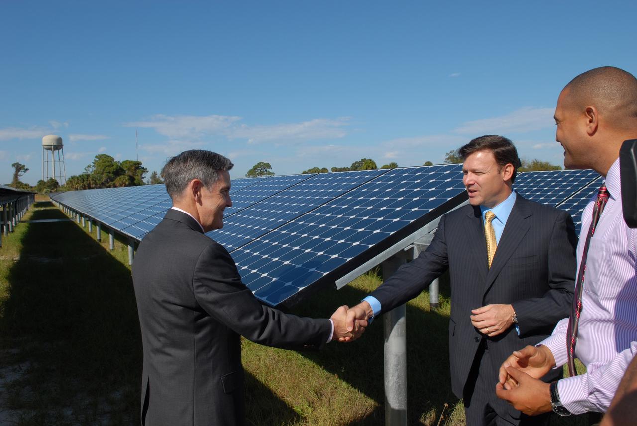 CAPE CANAVERAL, Fla. – At NASA's Kennedy Space Center in Florida, Kennedy Director Bob Cabana, left, congratulates, Eric Silagy, Florida Power & Light Company vice president and chief development officer, for his part in the construction of NASA's first large-scale solar power generation facility as Roderick Roche, senior manager, Project Management Office of North America, SunPower Corporation, looks on. Representatives from NASA, Florida Power & Light Company, or FPL, and SunPower Corporation formally commissioned the one-megawatt facility and announced plans to pursue a new research, development and demonstration project at Kennedy to advance America's use of renewable energy. The facility is the first element of a major renewable energy project currently under construction at Kennedy. The completed system features a fixed-tilt, ground-mounted solar power system designed and built by SunPower, along with SunPower solar panels. A 10-megawatt solar farm, which SunPower is building on nearby Kennedy property, will supply power to FPL's customers when it is completed in April 2010. Photo credit: NASA/Jim Grossmann