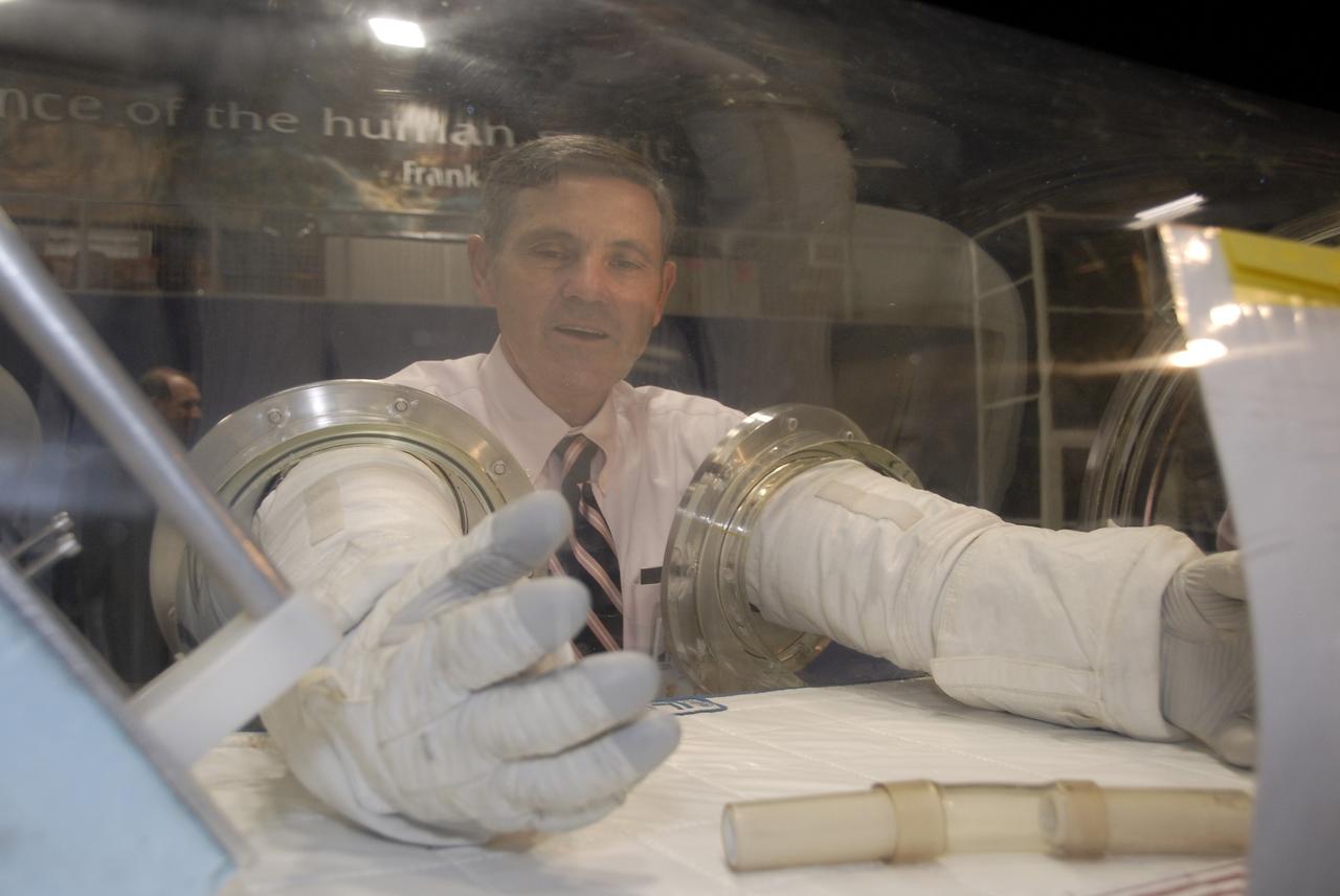 CAPE CANAVERAL, Fla. – At the Astronaut Hall of Fame near NASA’s Kennedy Space Center in Florida, Kennedy Director Bob Cabana, a former astronaut, tries out a pair of space gloves for their dexterity and flexibility in a glove box  at the 2009 Astronaut Glove Challenge, part of NASA’s Centennial Challenges Program.    The nationwide competition focused on developing improved pressure suit gloves for astronauts to use while working in space.  During the challenge, the gloves were submitted to burst tests, joint force tests and tests to measure their dexterity and strength during operation in a glove box which simulates the vacuum of space.  Centennial Challenges is NASA’s program of technology prizes for the citizen-inventor. The winning prize for the Glove Challenge is $250,000 provided by the Centennial Challenges Program.  Photo credit: NASA/Kim Shiflett