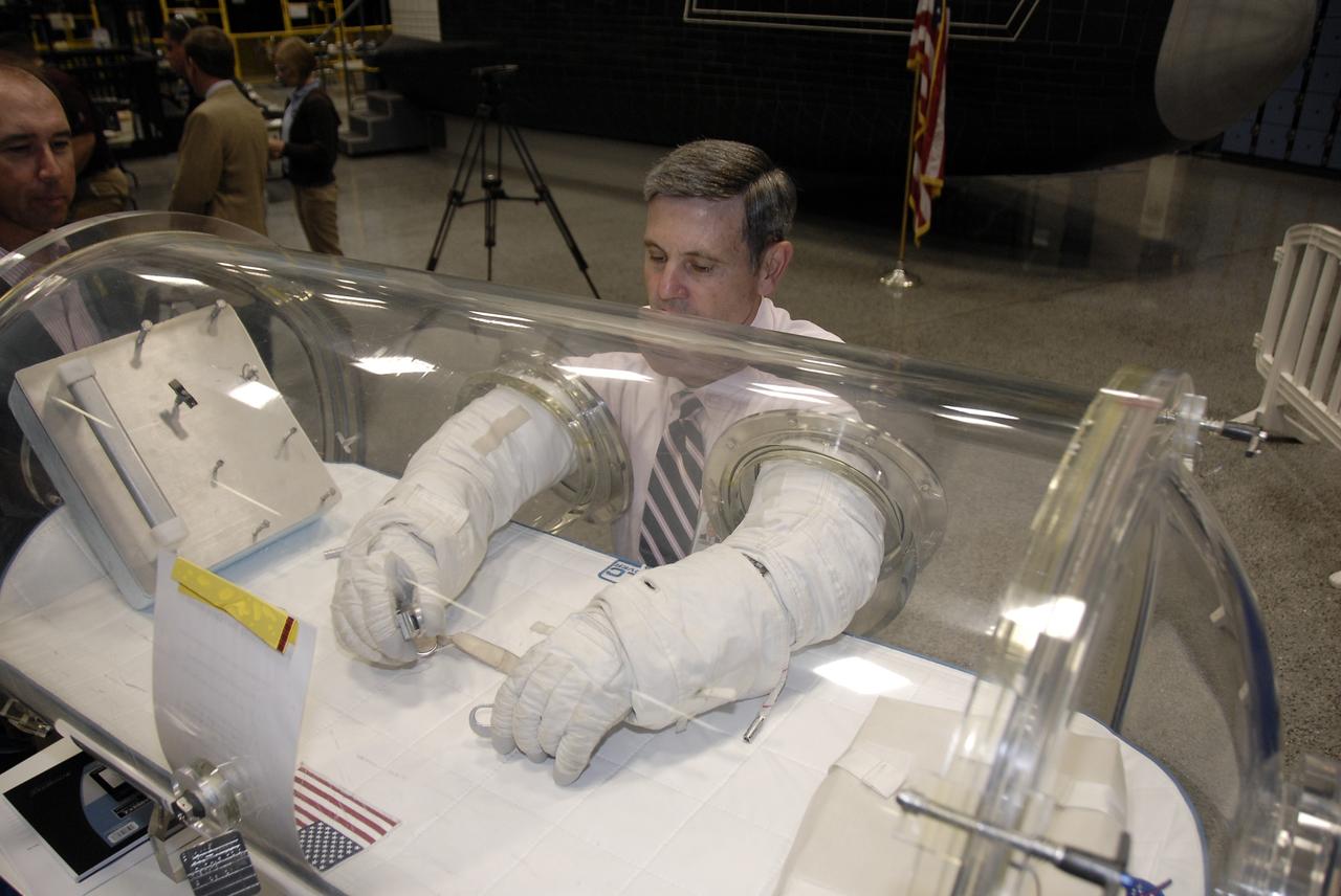 CAPE CANAVERAL, Fla. – At the Astronaut Hall of Fame near NASA’s Kennedy Space Center in Florida, Kennedy Director Bob Cabana, a former astronaut, tries out a pair of space gloves for their dexterity and flexibility in a glove box  at the 2009 Astronaut Glove Challenge, part of NASA’s Centennial Challenges Program.    The nationwide competition focused on developing improved pressure suit gloves for astronauts to use while working in space.  During the challenge, the gloves were submitted to burst tests, joint force tests and tests to measure their dexterity and strength during operation in a glove box which simulates the vacuum of space.  Centennial Challenges is NASA’s program of technology prizes for the citizen-inventor. The winning prize for the Glove Challenge is $250,000 provided by the Centennial Challenges Program.  Photo credit: NASA/Kim Shiflett