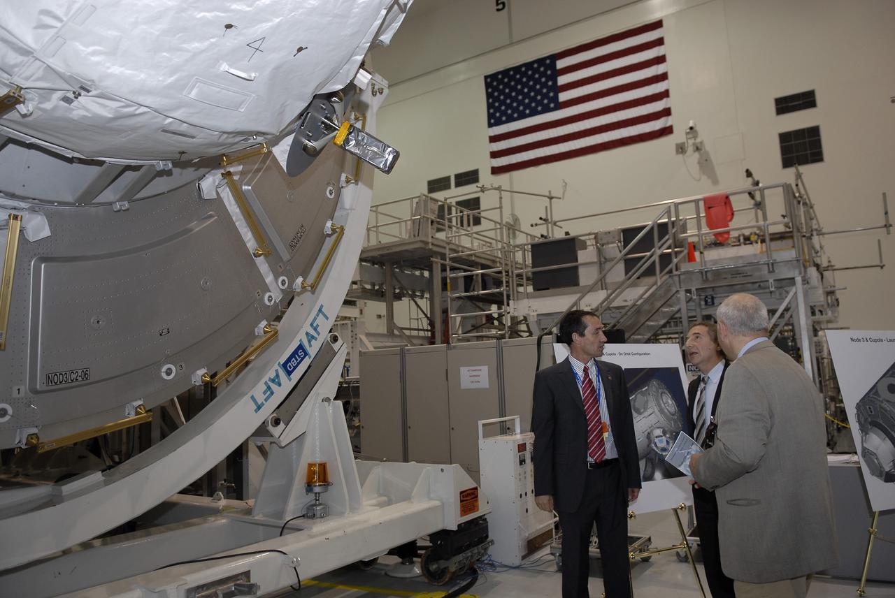 CAPE CANAVERAL, Fla. – In the Space Station Processing Facility at NASA's Kennedy Space Center in Florida, Bernardo Patti, center, head of International Space Station, Program Department, European Space Agency, or ESA, admires the node 3 for the International Space Station, which his agency provided, following a ceremony transferring the ownership of the node from ESA to NASA.    Node 3 is named "Tranquility" after the Sea of Tranquility, the lunar landing site of Apollo 11.  The payload for the STS-130 mission, Tranquility is a pressurized module that will provide room for many of the International Space Station's life support systems. The module was built for ESA by Thales Alenia Space in Turin, Italy. Attached to one end of Tranquility is a cupola, a unique work station with six windows on its sides and one on top.  The cupola resembles a circular bay window and will provide a vastly improved view of the station's exterior. Just under 10 feet in diameter, the module will accommodate two crew members and portable workstations that can control station and robotic activities. The multi-directional view will allow the crew to monitor spacewalks and docking operations, as well as provide a spectacular view of Earth and other celestial objects. Space shuttle Endeavour's STS-130 mission is targeted to launch Feb. 4, 2010. Photo credit: NASA/Kim Shiflett