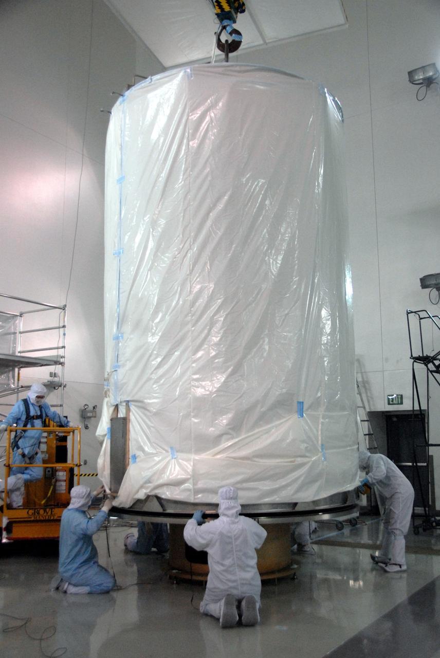 VANDENBERG AIR FORCE BASE, Calif. - At the Astrotech payload processing facility at Vandenberg Air Force Base in California, spacecraft technicians secure the transportation canister, in which NASA's Wide-field Infrared Survey Explorer, or WISE, is enclosed, to the direct mate adapter, a transport fixture, for the spacecraft's move to Space Launch Complex 2. WISE will survey the entire sky at infrared wavelengths, creating a cosmic clearinghouse of hundreds of millions of objects which will be catalogued and provide a vast storehouse of knowledge about the solar system, the Milky Way, and the universe. Launch aboard a United Launch Alliance Delta II rocket is scheduled for Dec. 9. For additional information, visit http://www.nasa.gov/wise. Photo credit: NASA/Daniel Liberotti, VAFB