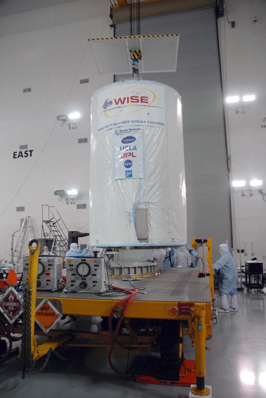 VANDENBERG AIR FORCE BASE, Calif. - At the Astrotech payload processing facility at Vandenberg Air Force Base in California, spacecraft technicians lower a transportation canister containing NASA's Wide-field Infrared Survey Explorer, or WISE, onto a transporter for its move to Space Launch Complex 2. WISE will survey the entire sky at infrared wavelengths, creating a cosmic clearinghouse of hundreds of millions of objects which will be catalogued and provide a vast storehouse of knowledge about the solar system, the Milky Way, and the universe. Launch aboard a United Launch Alliance Delta II rocket is scheduled for Dec. 9. For additional information, visit http://www.nasa.gov/wise. Photo credit: NASA/Daniel Liberotti, VAFB