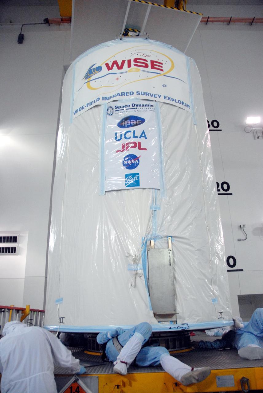 VANDENBERG AIR FORCE BASE, Calif. - At the Astrotech payload processing facility at Vandenberg Air Force Base in California, spacecraft technicians check the position of a transportation canister containing NASA's Wide-field Infrared Survey Explorer, or WISE, on the transporter which will move it to Space Launch Complex 2. WISE will survey the entire sky at infrared wavelengths, creating a cosmic clearinghouse of hundreds of millions of objects which will be catalogued and provide a vast storehouse of knowledge about the solar system, the Milky Way, and the universe. Launch aboard a United Launch Alliance Delta II rocket is scheduled for Dec. 9. For additional information, visit http://www.nasa.gov/wise. Photo credit: NASA/Daniel Liberotti, VAFB