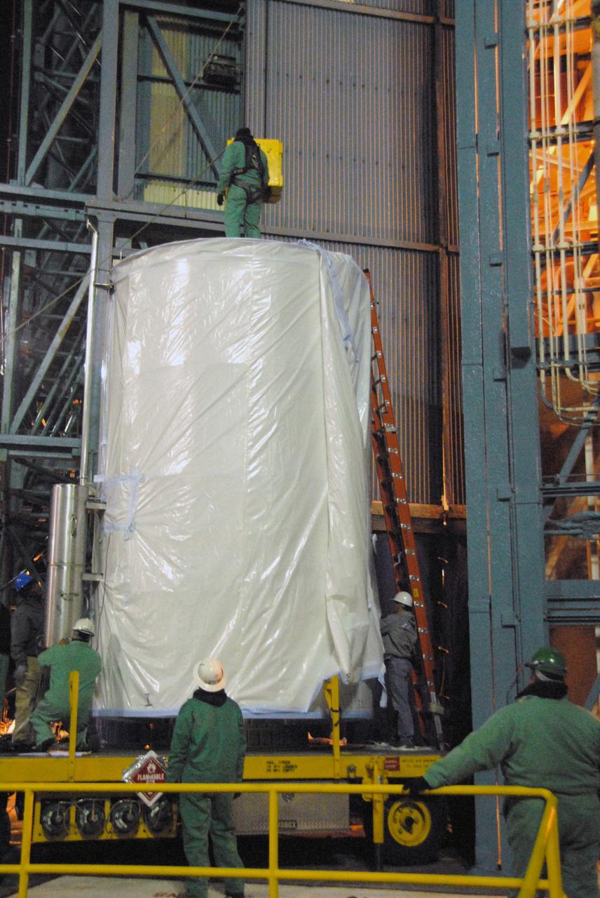VANDENBERG AIR FORCE BASE, Calif. - Spacecraft technicians prepare to unwrap the weather protective covering from the transportation canister for NASA's Wide-field Infrared Survey Explorer, or WISE, at Space Launch Complex 2 at Vandenberg Air Force Base in California.    WISE will survey the entire sky at infrared wavelengths, creating a cosmic clearinghouse of hundreds of millions of objects which will be catalogued and provide a vast storehouse of knowledge about the solar system, the Milky Way, and the universe. Launch is scheduled for Dec. 9.  For additional information, visit http://www.nasa.gov/wise.  Photo credit: NASA/Mark Mackley, VAFB