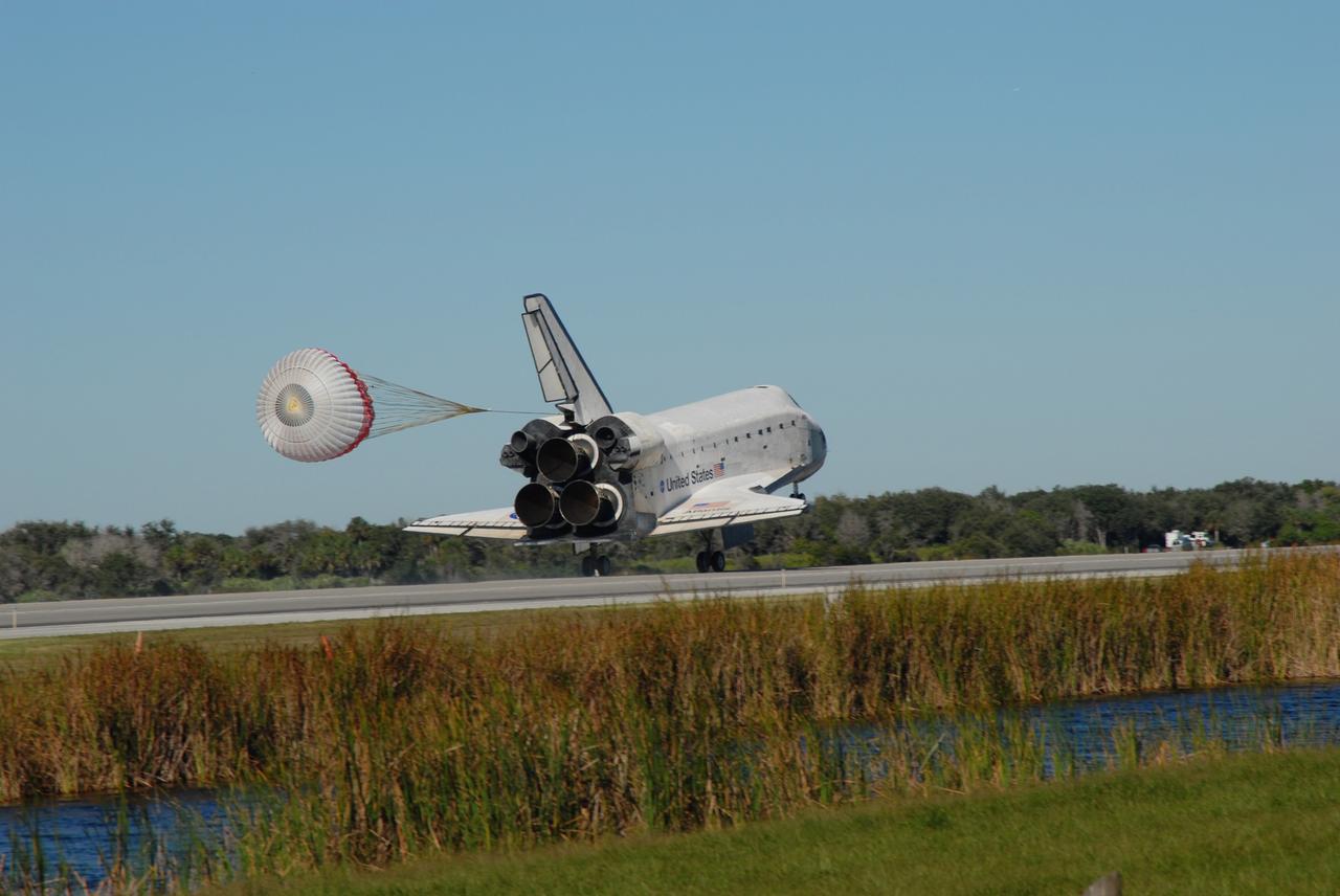 CAPE CANAVERAL, Fla. - The drag chute unfurls to slow space shuttle Atlantis for landing on Runway 33 at the Shuttle Landing Facility at NASA's Kennedy Space Center in Florida after 11 days in space, completing the 4.5-million mile STS-129 mission on orbit 171.    Main gear touchdown was at 9:44:23 a.m. EST. Nose gear touchdown was at 9:44:36 a.m., and wheels stop was at 9:45:05 a.m. Aboard Atlantis are Commander Charles O. Hobaugh; Pilot Barry E. Wilmore; Mission Specialists Leland Melvin, Randy Bresnik, Mike Foreman and Robert L. Satcher Jr.; and Expedition 20 and 21 Flight Engineer Nicole Stott who spent 87 days aboard the International Space Station. STS-129 is the final space shuttle Expedition crew rotation flight on the manifest. On STS-129, the crew delivered 14 tons of cargo to the orbiting laboratory, including two ExPRESS Logistics Carriers containing spare parts to sustain station operations after the shuttles are retired next year. For information on the STS-129 mission and crew, visit http://www.nasa.gov/mission_pages/shuttle/shuttlemissions/sts129/index.html. Photo credit: NASA/Jim Grossmann