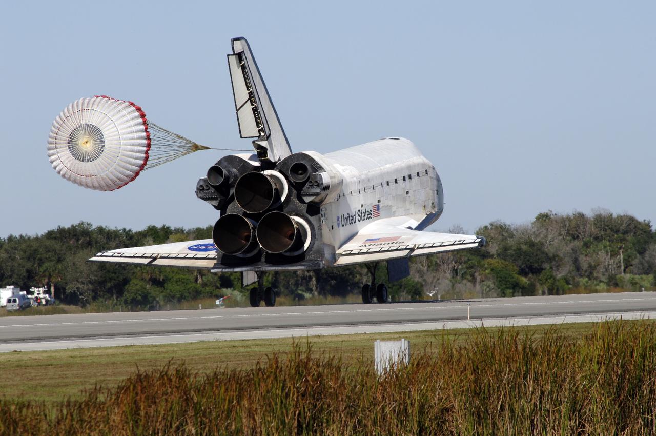 CAPE CANAVERAL, Fla. - With drag chute unfurled, space shuttle Atlantis lands on Runway 33 at the Shuttle Landing Facility at NASA's Kennedy Space Center in Florida after 11 days in space, completing the 4.5-million mile STS-129 mission on orbit 171.    Main gear touchdown was at 9:44:23 a.m. EST. Nose gear touchdown was at 9:44:36 a.m., and wheels stop was at 9:45:05 a.m. Aboard Atlantis are Commander Charles O. Hobaugh; Pilot Barry E. Wilmore; Mission Specialists Leland Melvin, Randy Bresnik, Mike Foreman and Robert L. Satcher Jr.; and Expedition 20 and 21 Flight Engineer Nicole Stott who spent 87 days aboard the International Space Station. STS-129 is the final space shuttle Expedition crew rotation flight on the manifest. On STS-129, the crew delivered 14 tons of cargo to the orbiting laboratory, including two ExPRESS Logistics Carriers containing spare parts to sustain station operations after the shuttles are retired next year. For information on the STS-129 mission and crew, visit http://www.nasa.gov/mission_pages/shuttle/shuttlemissions/sts129/index.html. Photo credit: NASA/Kim Shiflett