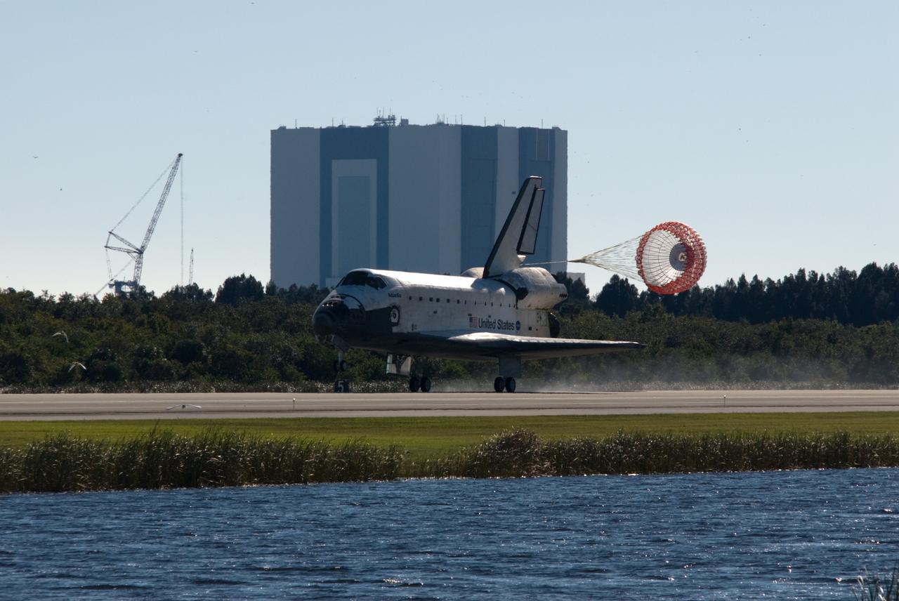 CAPE CANAVERAL, Fla. - With its drag chute unfurled, space shuttle Atlantis touches down on Runway 33 at the Shuttle Landing Facility at NASA's Kennedy Space Center in Florida after 11 days in space, completing the 4.5-million mile STS-129 mission on orbit 171.  In the background are the 525-foot-tall Vehicle Assembly Building and a crane being used to construct a new mobile launcher to support the Constellation Program's Ares I rocket.    Main gear touchdown was at 9:44:23 a.m. EST. Nose gear touchdown was at 9:44:36 a.m., and wheels stop was at 9:45:05 a.m.  Aboard Atlantis are Commander Charles O. Hobaugh; Pilot Barry E. Wilmore; Mission Specialists Leland Melvin, Randy Bresnik, Mike Foreman and Robert L. Satcher Jr.; and Expedition 20 and 21 Flight Engineer Nicole Stott who spent 87 days aboard the International Space Station.  STS-129 is the final space shuttle Expedition crew rotation flight on the manifest.  On STS-129, the crew delivered 14 tons of cargo to the orbiting laboratory, including two ExPRESS Logistics Carriers containing spare parts to sustain station operations after the shuttles are retired next year.  For information on the STS-129 mission and crew, visit http://www.nasa.gov/mission_pages/shuttle/shuttlemissions/sts129/index.html.     Photo credit: NASA/Tim Terry