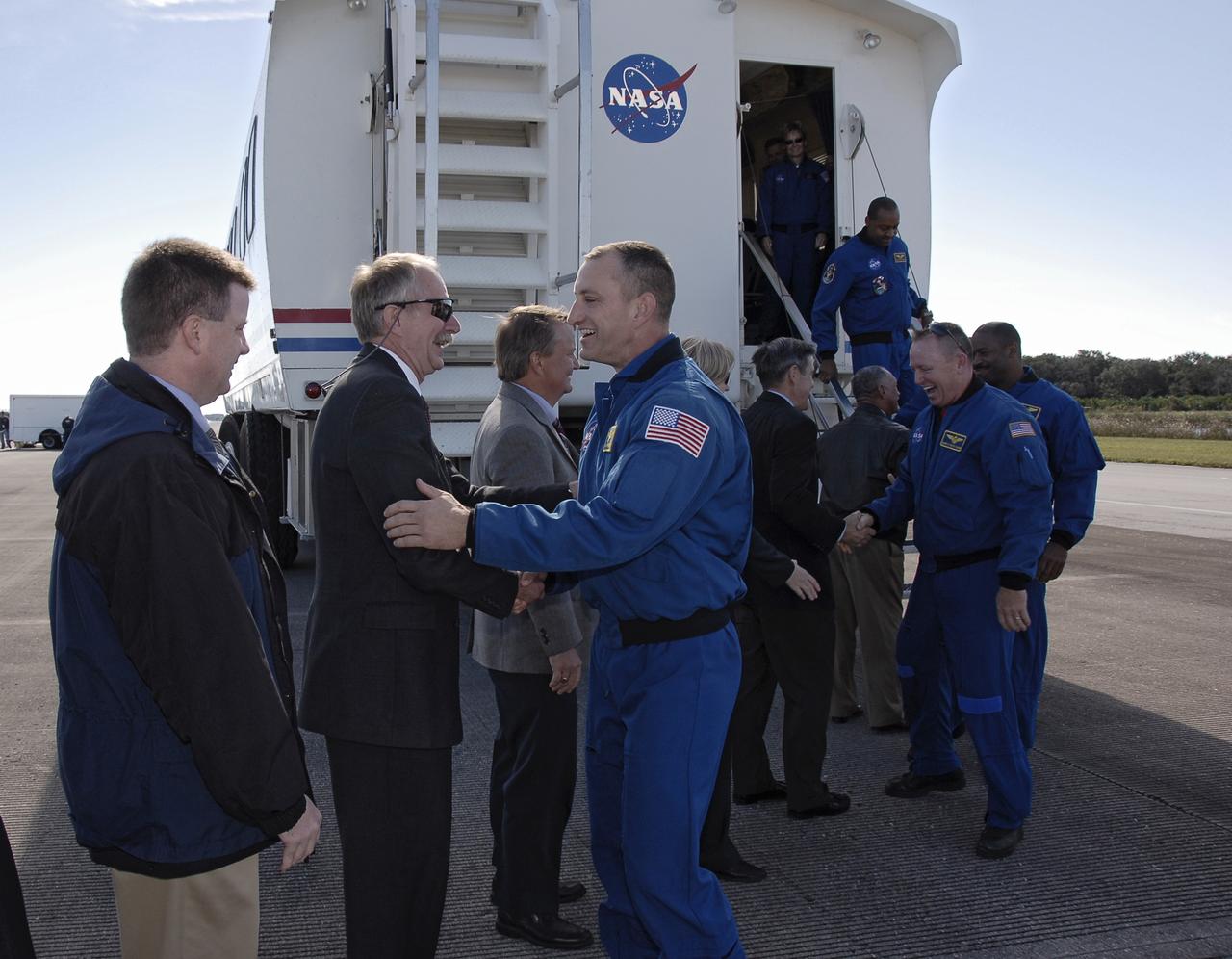 CAPE CANAVERAL, Fla. - At the Shuttle Landing Facility at NASA's Kennedy Space Center in Florida, NASA Associate Administrator for Space Operations Bill Gerstenmaier, wearing sunglasses, congratulates STS-129 Commander Charles O. Hobaugh on a successful mission.  Space Shuttle Launch Integration Manager Mike Moses looks on, at left.  Space shuttle Atlantis landed on Runway 33, completing the 4.5-million-mile STS-129 mission to the International Space Station on orbit 171.  Main gear touchdown was at 9:44:23 a.m. EST. Nose gear touchdown was at 9:44:36 a.m., and wheels stop was at 9:45:05 a.m.  On STS-129, the six-member crew delivered 14 tons of cargo to the orbiting laboratory, including two ExPRESS Logistics Carriers containing spare parts to sustain station operations after the shuttles are retired next year.  For information on the STS-129 mission and crew, visit http://www.nasa.gov/mission_pages/shuttle/shuttlemissions/sts129/index.html.    Photo credit: NASA/Kim Shiflett