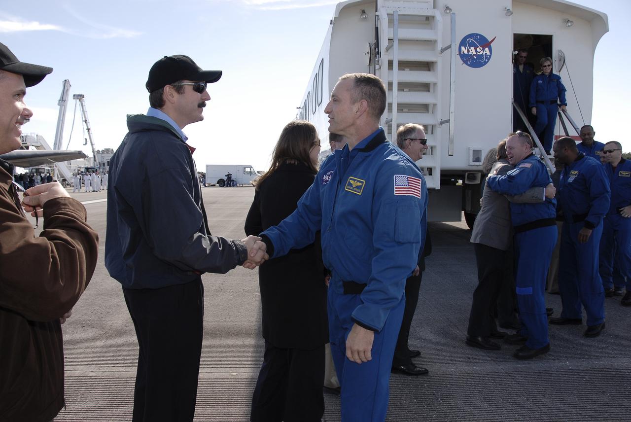 CAPE CANAVERAL, Fla. - At the Shuttle Landing Facility at NASA's Kennedy Space Center in Florida, a receiving line of NASA managers and well-wishers congratulate the members of the STS-129 crew on a successful mission.  In line from left, in the blue suits, are STS-129 Commander Charles O. Hobaugh; Pilot Barry E. Wilmore; and Mission Specialists Leland Melvin, Randy Bresnik and Robert L. Satcher Jr.  Looking on from the top of the stairs is astronaut Peggy Whitson, chief of the Astronaut Corps, who has spent a total of 377 days in space while a member of two Expedition crews on the International Space Station.  Space shuttle Atlantis landed on Runway 33, completing the 4.5-million-mile STS-129 mission to the International Space Station on orbit 171.  Main gear touchdown was at 9:44:23 a.m. EST. Nose gear touchdown was at 9:44:36 a.m., and wheels stop was at 9:45:05 a.m.  On STS-129, the six-member crew delivered 14 tons of cargo to the orbiting laboratory, including two ExPRESS Logistics Carriers containing spare parts to sustain station operations after the shuttles are retired next year.  For information on the STS-129 mission and crew, visit http://www.nasa.gov/mission_pages/shuttle/shuttlemissions/sts129/index.html.    Photo credit: NASA/Kim Shiflett