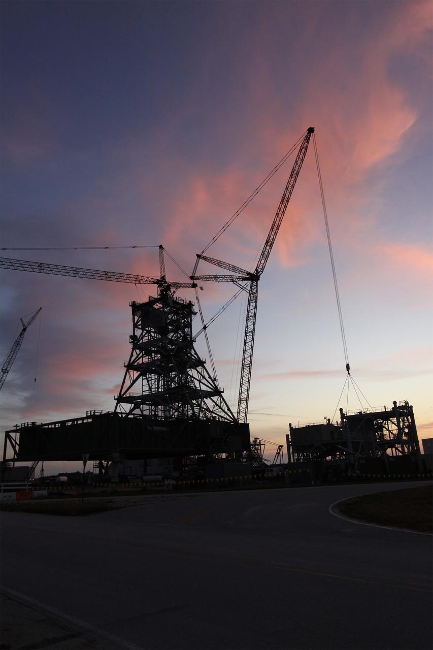 CAPE CANAVERAL, Fla. – As the sun rises over NASA's Kennedy Space Center in Florida, preparations are under way to continue construction of a new mobile launcher, or ML, to support the Constellation Program. When completed, the tower will be approximately 345 feet tall and have multiple platforms for personnel access. The construction is under way at the mobile launcher park site area north of Kennedy's Vehicle Assembly Building. The launcher will provide a base to launch the Ares I rocket, designed to transport the Orion crew exploration vehicle, its crew and cargo to low Earth orbit. Its base is being made lighter than space shuttle mobile launcher platforms so the crawler-transporter can pick up the heavier load of the tower and taller rocket. For information on the Ares I, visit http://www.nasa.gov/ares. Photo credit: NASA/Jack Pfaller