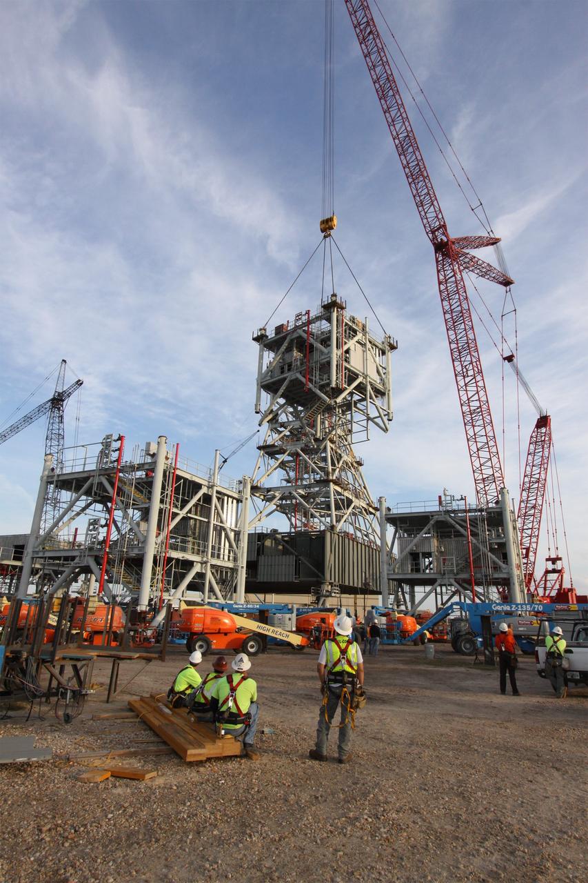 CAPE CANAVERAL, Fla. – At NASA's Kennedy Space Center in Florida, the fifth tower segment is lifted toward four segments already secured to a new mobile launcher, or ML, being constructed to support the Constellation Program. When completed, the tower will be approximately 345 feet tall and have multiple platforms for personnel access. The construction is under way at the mobile launcher park site area north of Kennedy's Vehicle Assembly Building. The launcher will provide a base to launch the Ares I rocket, designed to transport the Orion crew exploration vehicle, its crew and cargo to low Earth orbit. Its base is being made lighter than space shuttle mobile launcher platforms so the crawler-transporter can pick up the heavier load of the tower and taller rocket. For information on the Ares I, visit http://www.nasa.gov/ares. Photo credit: NASA/Jack Pfaller