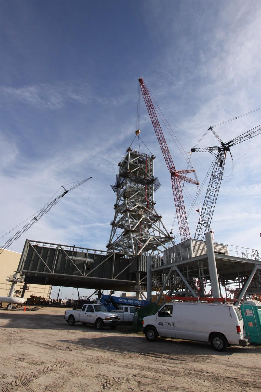 CAPE CANAVERAL, Fla. – At NASA's Kennedy Space Center in Florida, the tower on a new mobile launcher, or ML, for the Constellation Program grows as the fifth tower segment is balanced in position. When completed, the tower will be approximately 345 feet tall and have multiple platforms for personnel access. The construction is under way at the mobile launcher park site area north of Kennedy's Vehicle Assembly Building. The launcher will provide a base to launch the Ares I rocket, designed to transport the Orion crew exploration vehicle, its crew and cargo to low Earth orbit. Its base is being made lighter than space shuttle mobile launcher platforms so the crawler-transporter can pick up the heavier load of the tower and taller rocket. For information on the Ares I, visit http://www.nasa.gov/ares. Photo credit: NASA/Jack Pfaller