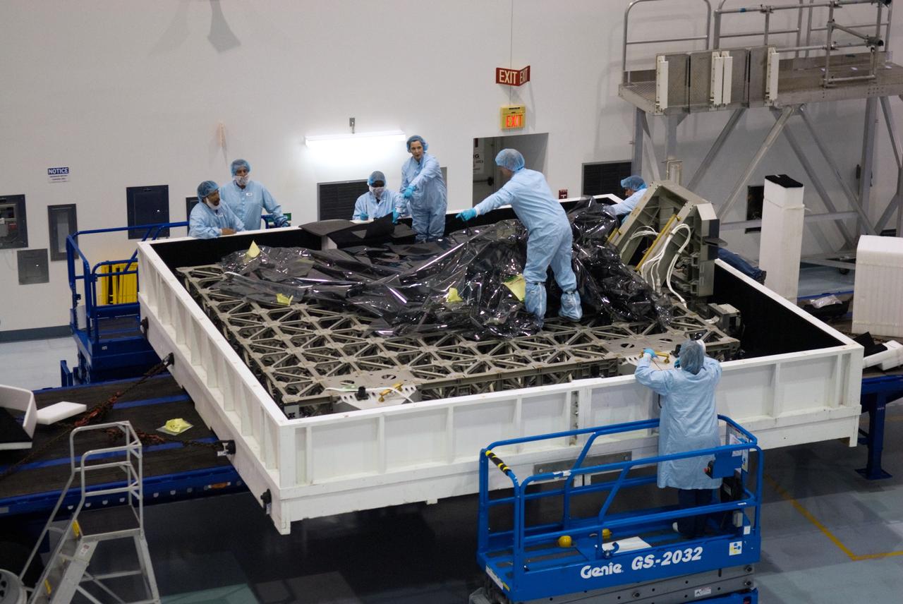 CAPE CANAVERAL, Fla. - In the Space Station Processing Facility at NASA's Kennedy Space Center in Florida, workers unwrap the ExPRESS Logistics Carrier 3, or ELC-3, still nestled in its transportation case.    ELC-3 and the Alpha Magnetic Spectrometer are the primary payloads for space shuttle Endeavour's STS-134 mission to the International Space Station. The STS-134 crew will also deliver spare parts including two S-band communications antennas, a high pressure gas tank, additional spare parts for Dextre and micrometeoroid debris shields.  Endeavour's launch is targeted for July 29, 2010. For information on the STS-134 mission objectives and crew, visit http://www.nasa.gov/shuttle. Photo credit: NASA/Kim Shiflett
