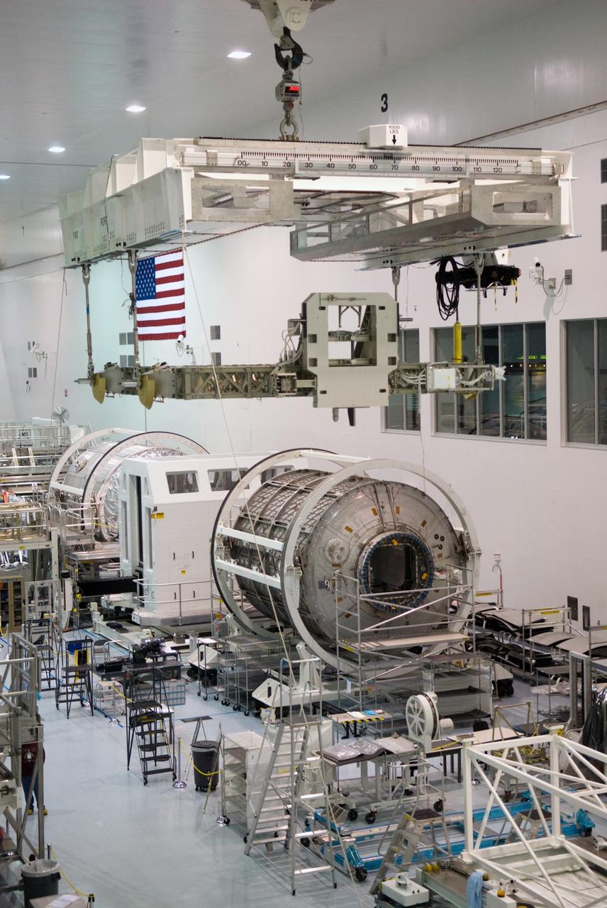 CAPE CANAVERAL, Fla. - In the Space Station Processing Facility at NASA's Kennedy Space Center in Florida, the newly arrived ExPRESS Logistics Carrier 3, or ELC-3, is lifted above two Multi-Purpose Logistics Modules positioned along the wall of the clean room. ELC-3 and the Alpha Magnetic Spectrometer are the primary payloads for space shuttle Endeavour's STS-134 mission to the International Space Station. The STS-134 crew will also deliver spare parts including two S-band communications antennas, a high pressure gas tank, additional spare parts for Dextre and micrometeoroid debris shields. Endeavour's launch is targeted for July 29, 2010. For information on the STS-134 mission objectives and crew, visit http://www.nasa.gov/shuttle. Photo credit: NASA/Kim Shiflett