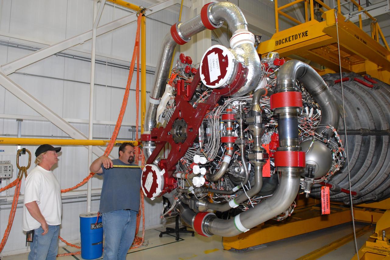 CAPE CANAVERAL, Fla. - In the Space Shuttle Main Engine Processing Facility at NASA's Kennedy Space Center in Florida, United Space Alliance workers carefully consider their readiness to lift a main engine. The engine is being moved to Orbiter Processing Facility Bay 3 where it will be installed in space shuttle Discovery during processing for the shuttle's STS-131 mission to the International Space Station. The seven-member STS-131 crew will deliver a Multi-Purpose Logistics Module filled with resupply stowage platforms and racks to be transferred to locations around the station. Three spacewalks will include work to attach a spare ammonia tank assembly to the station's exterior and return a European experiment from outside the station's Columbus module. Discovery's launch, targeted for March 18, 2010, will initiate the 33rd shuttle mission to the station. For information on the STS-131 mission and crew, visit http://www.nasa.gov/mission_pages/shuttle/shuttlemissions/sts131/index.html. Photo credit: NASA/Jim Grossmann